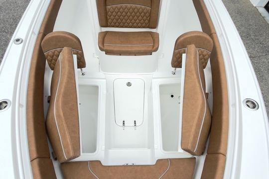 2026 Sea Hunt Ultra 255 SE boat interior with tan cushioned seating and storage compartments.