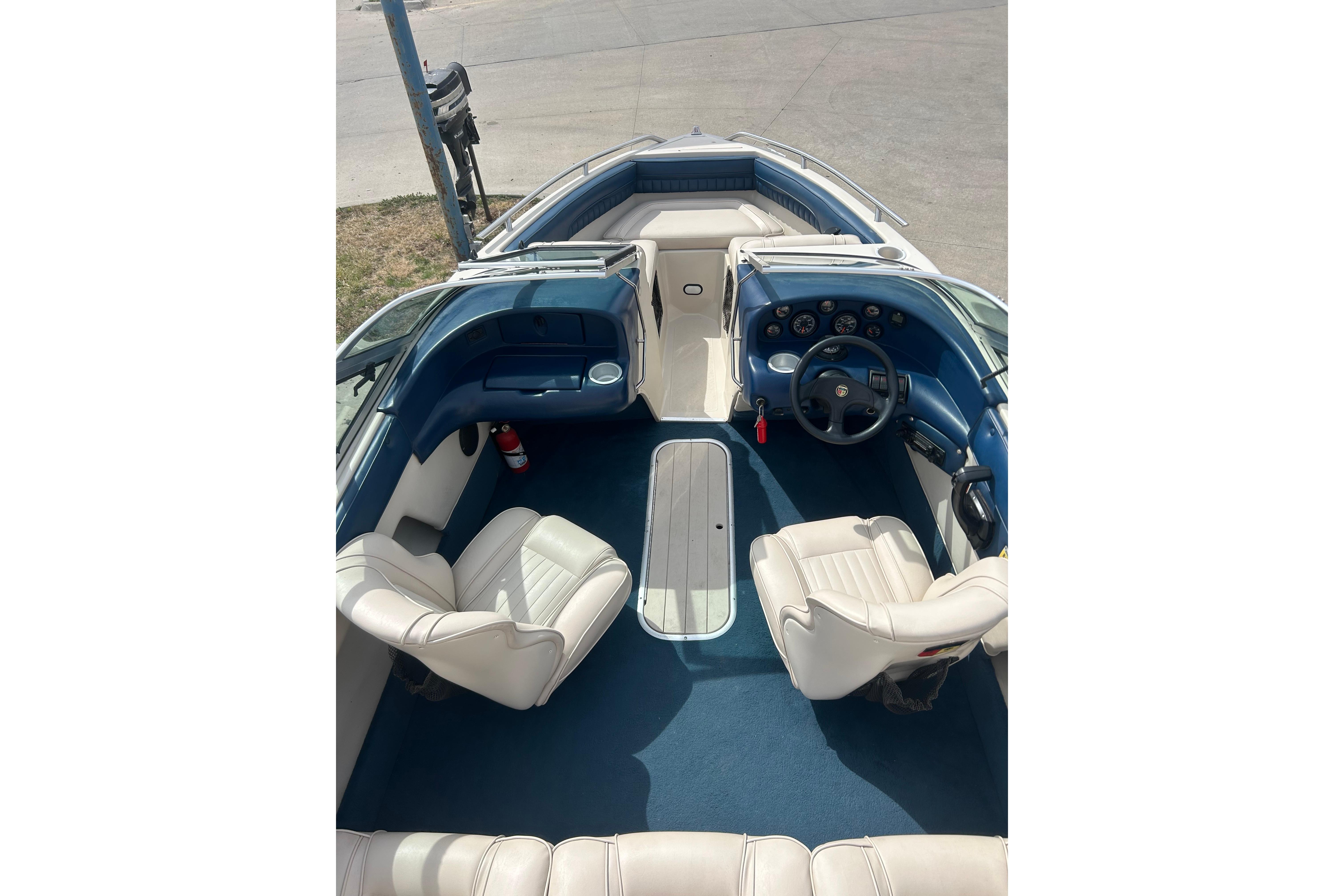 1996 Mariah 180 Shabah boat interior with blue and white seating and dashboard.