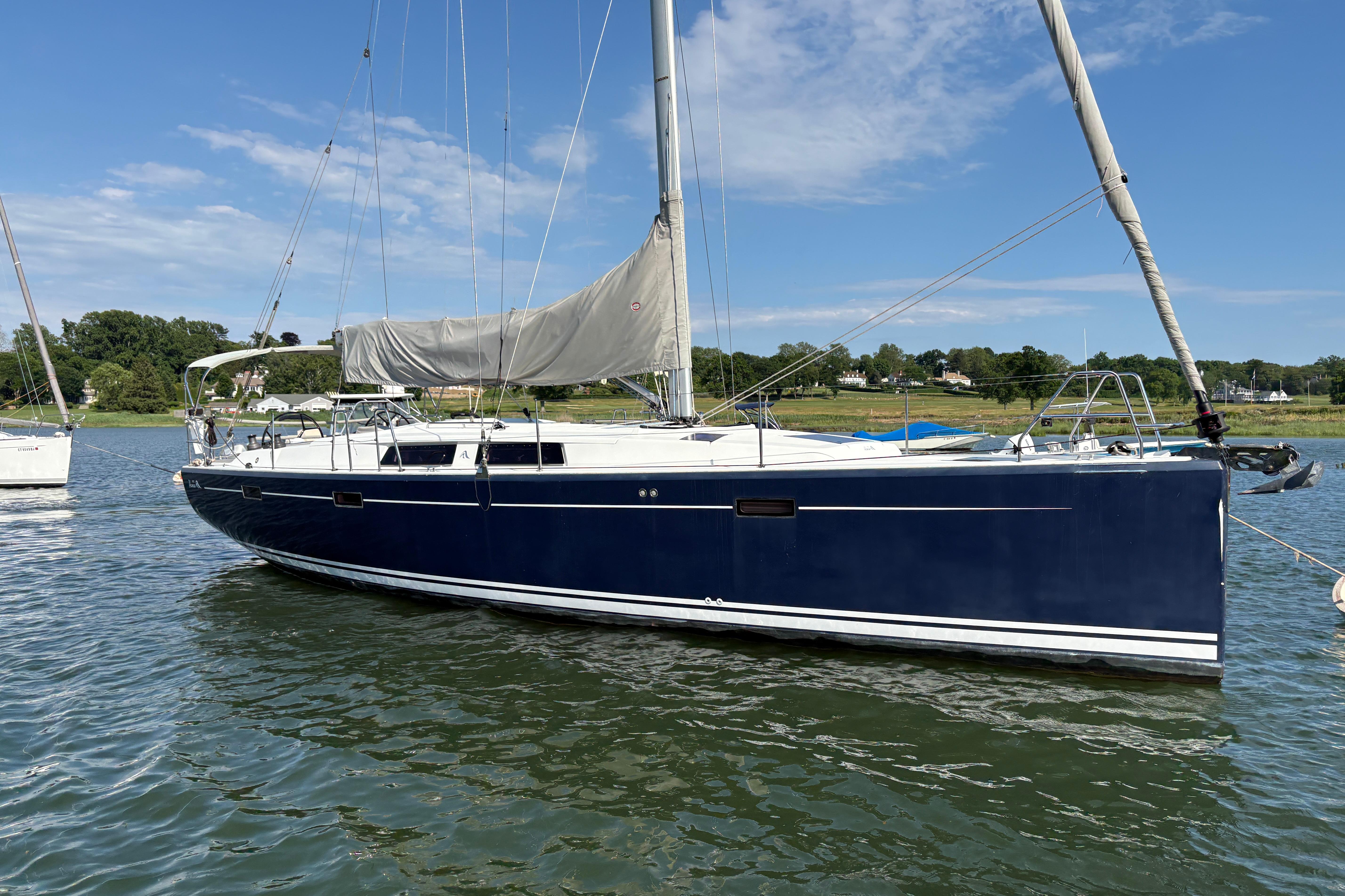 2014 Hanse 415 sailboat with blue hull, anchored on a sunny day.