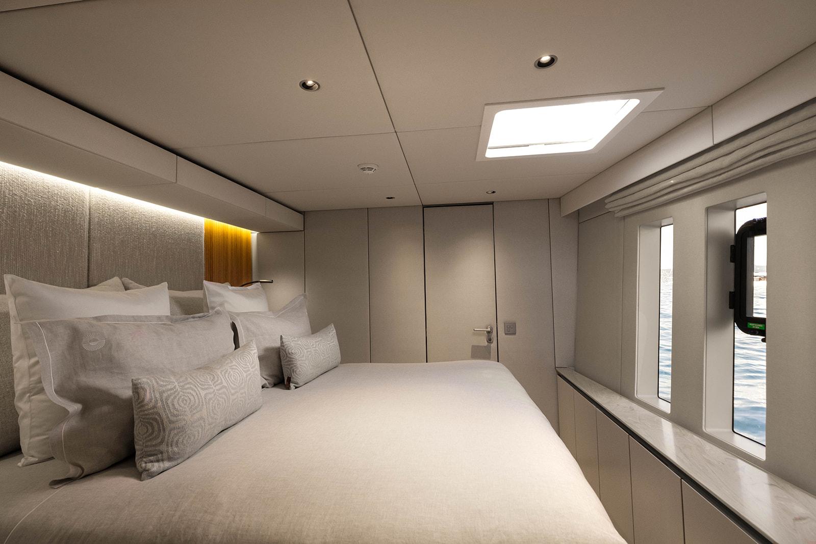 Luxurious bedroom interior of 2023 Sunreef 80 Eco yacht with modern design and natural light.
