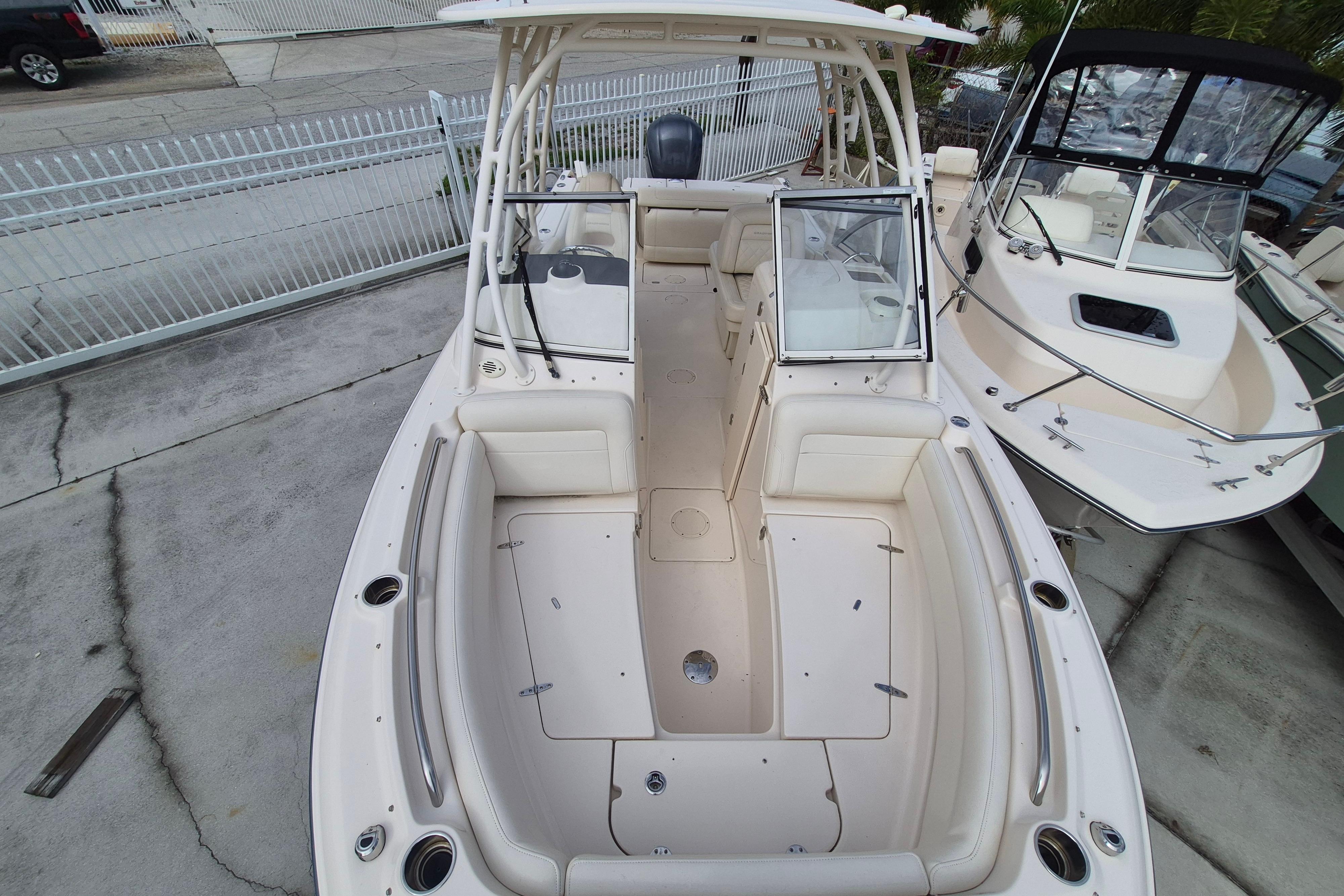 2020 Grady-White Freedom 335 boat, spacious deck, white seating, docked beside another boat.
