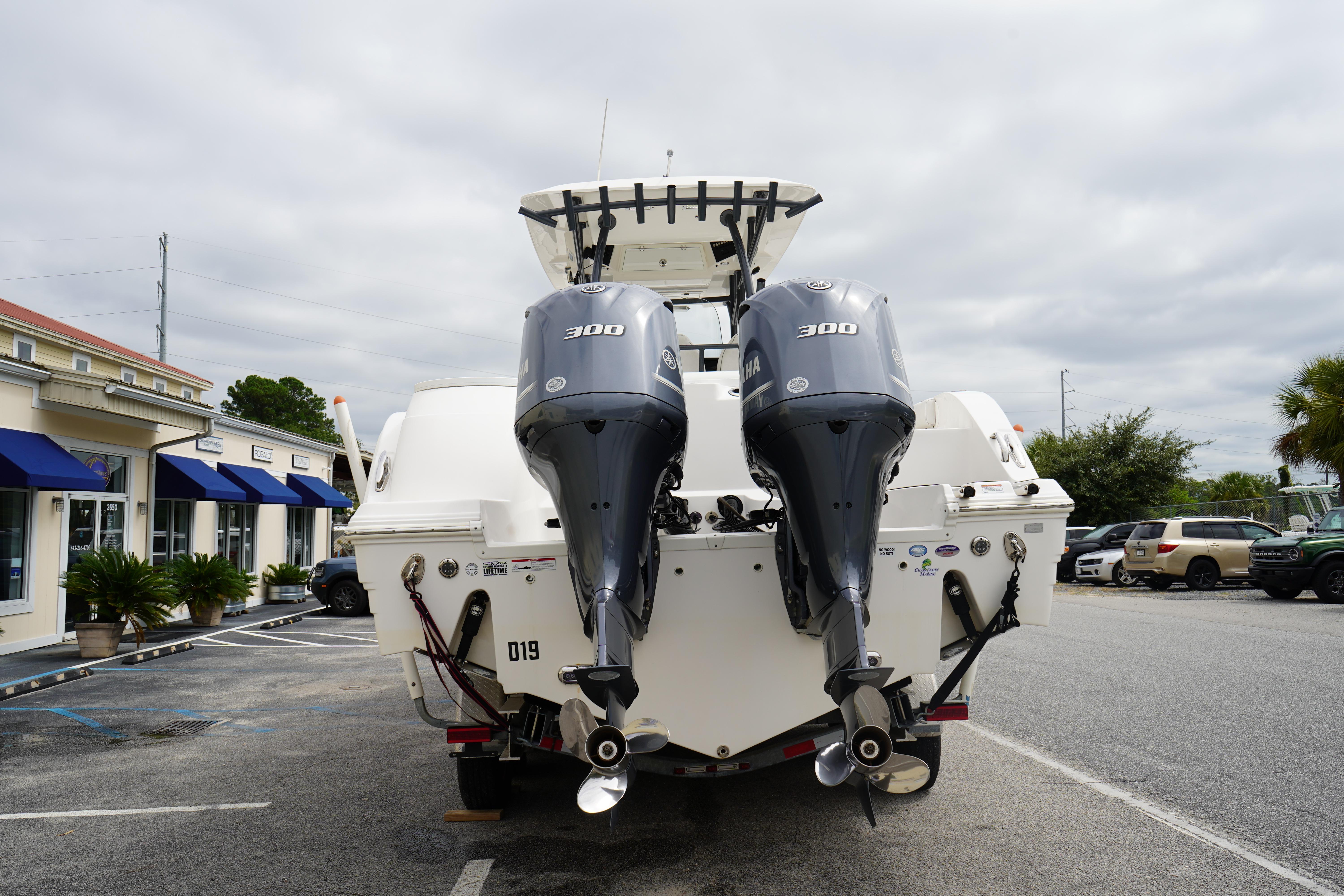 2020 Sea Fox 328 Commander boat with dual 300 horsepower engines in a parking lot.