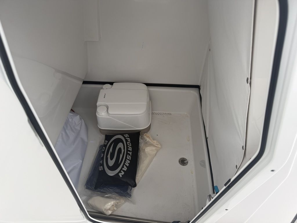 Interior of a boat with a portable toilet and Sportsman cushion.