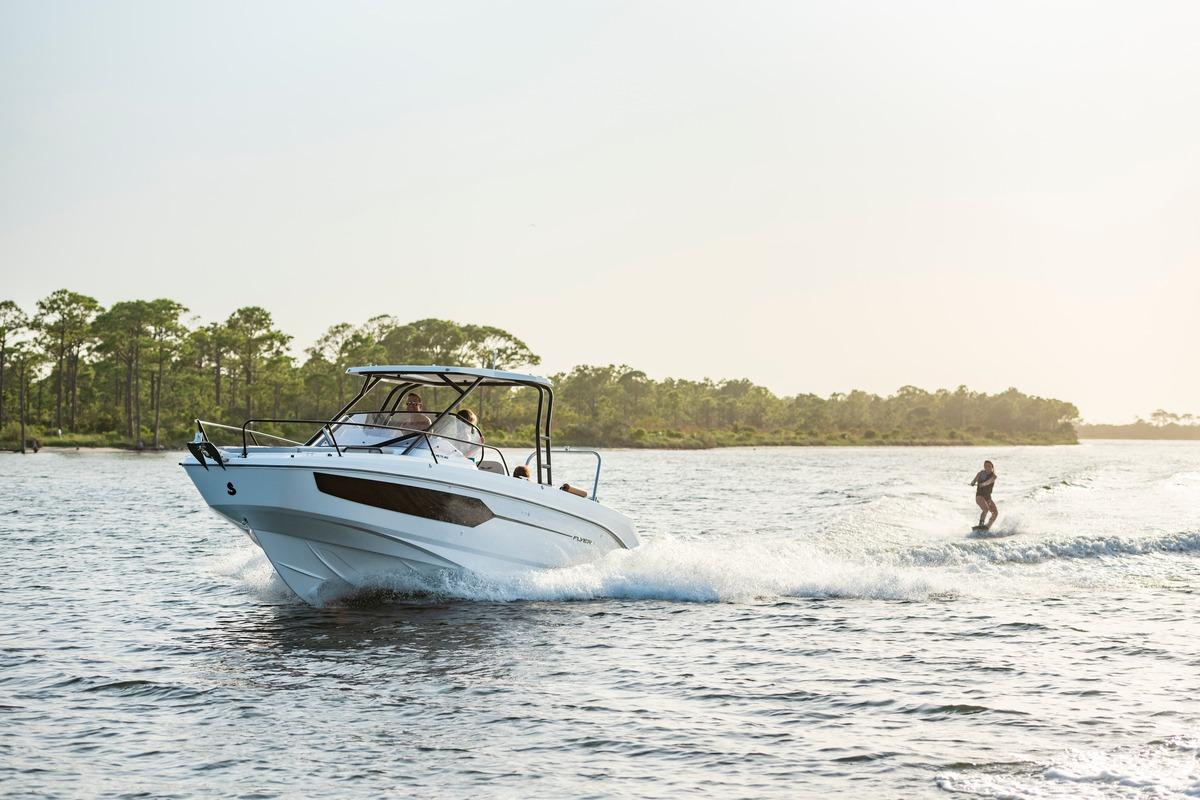 2026 Beneteau Flyer 8 SUNdeck cruising with wakeboarder on a sunny day.