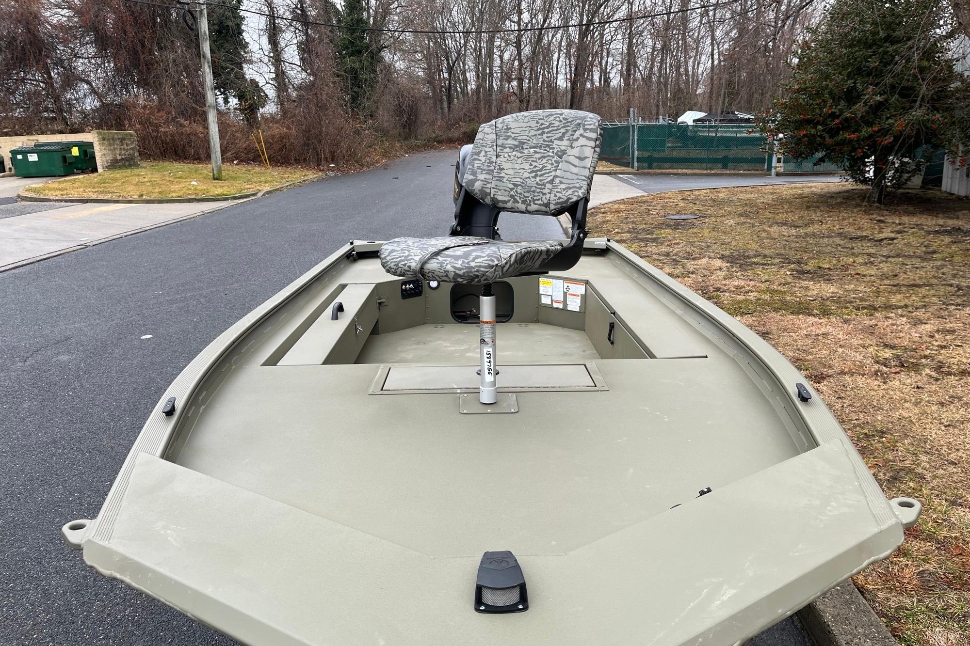 2026 Tracker Grizzly 1654 T Sportsman boat with camo seat on a street.