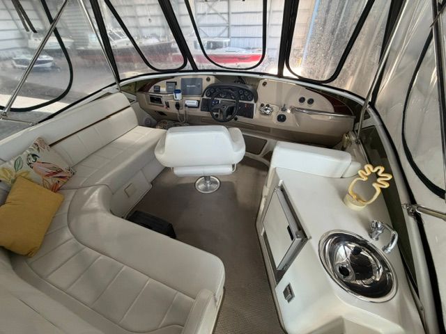Interior of a 2005 Carver 44 Cockpit Motor Yacht with white seating and helm console.