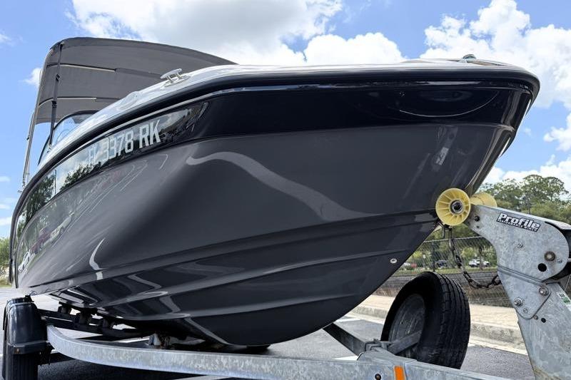 2017 Yamaha Boats SX210 on trailer, sleek black hull, under a cloudy sky.
