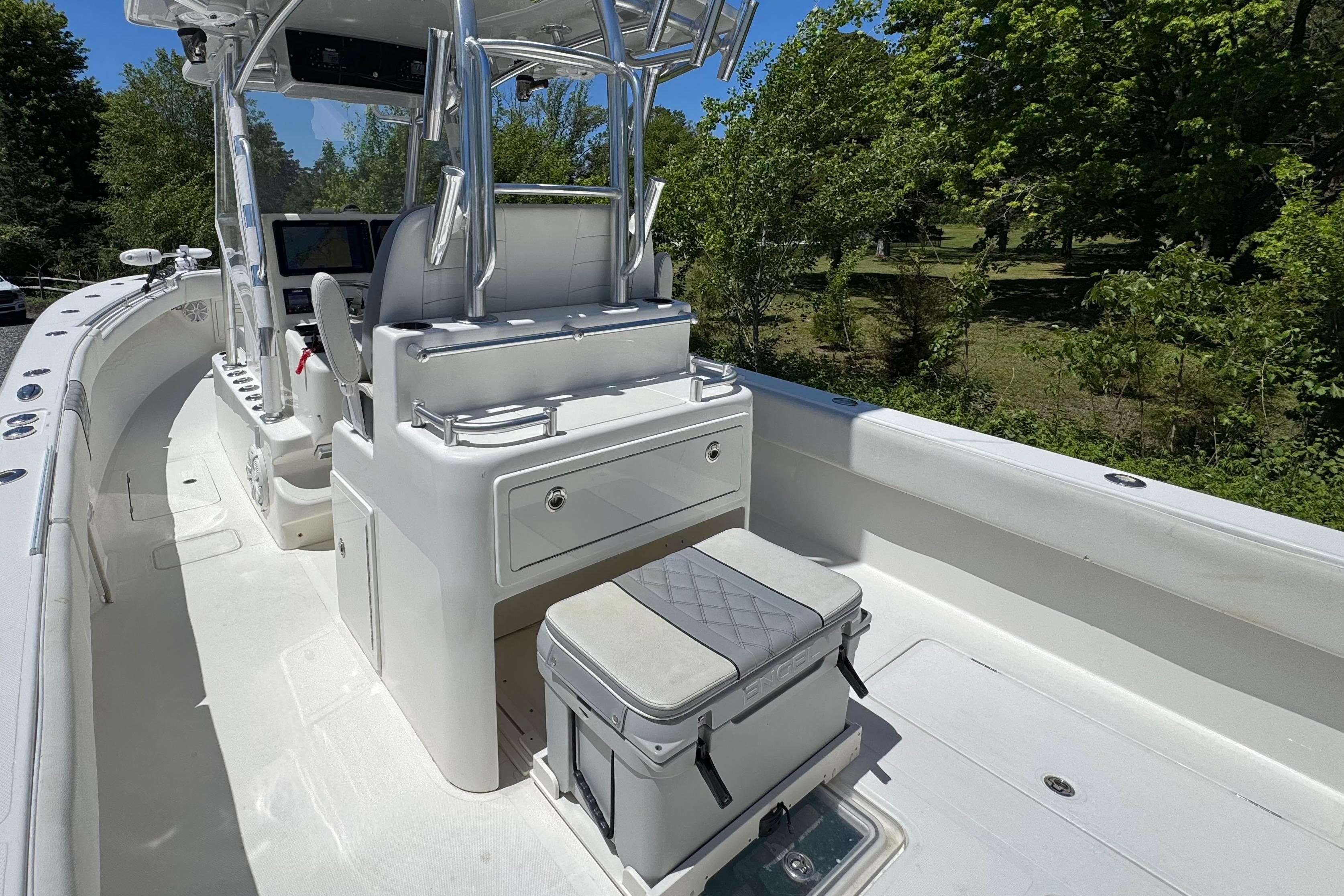 2020 Sea-Lion 34 TE boat interior with seating and console, surrounded by lush greenery.