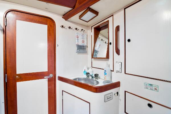 1989 Concordia 52 yacht bathroom with sink, mirror, and wooden accents.