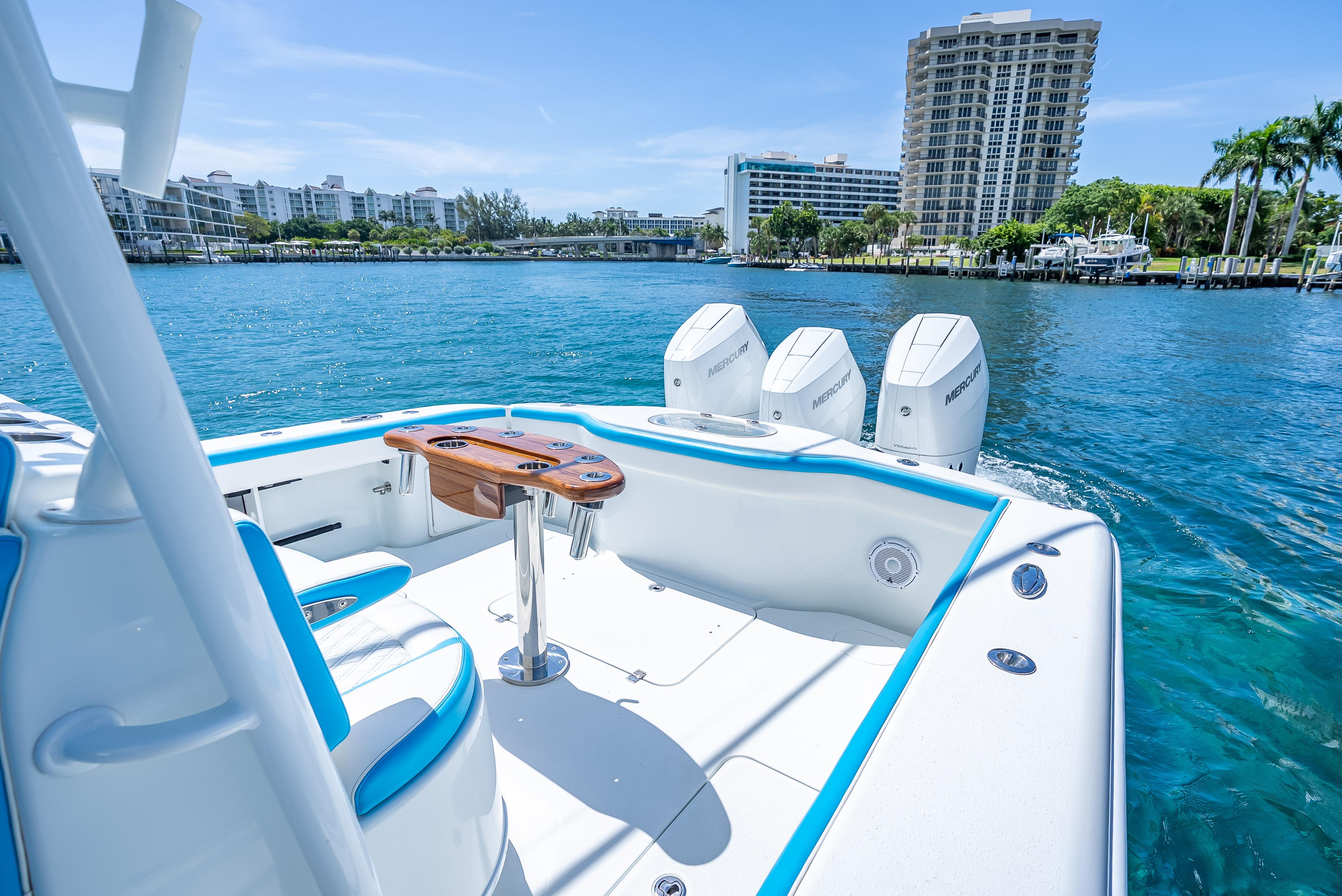 2016 Yellowfin 39 Offshore boat with triple Mercury engines on a sunny waterfront.