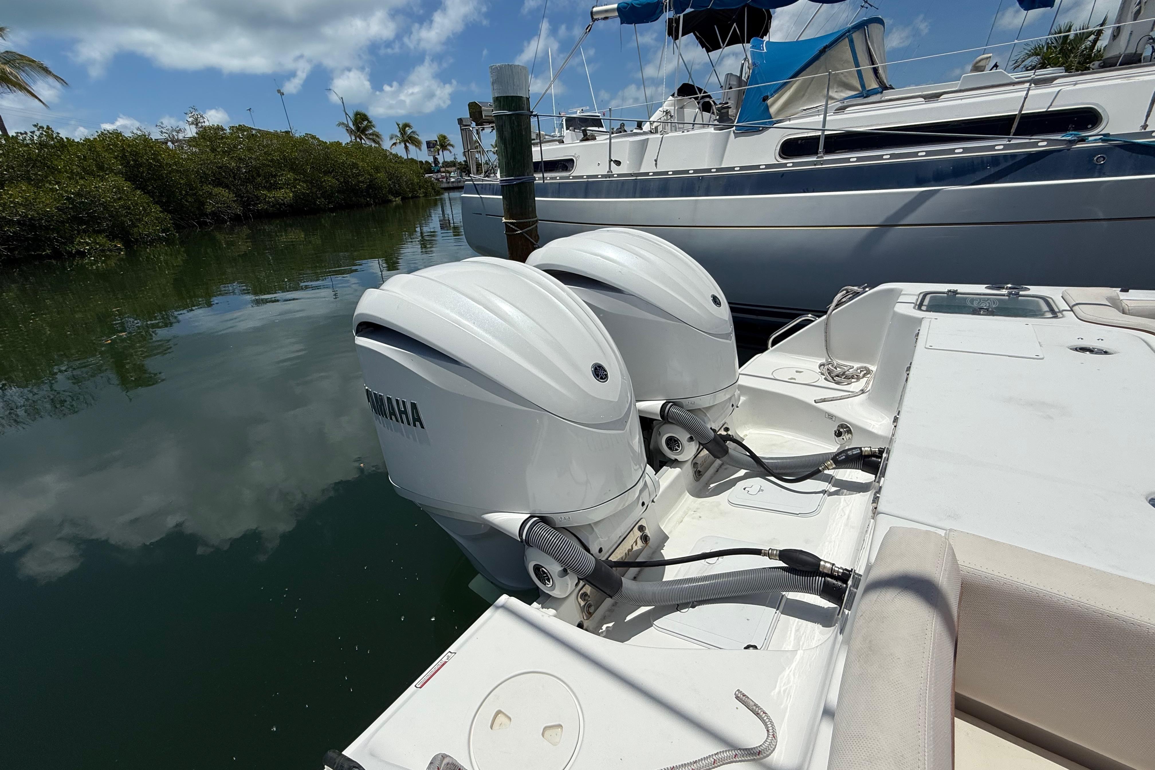 2022 Sea Hunt Gamefish 30 with twin Yamaha outboard motors docked by a marina.
