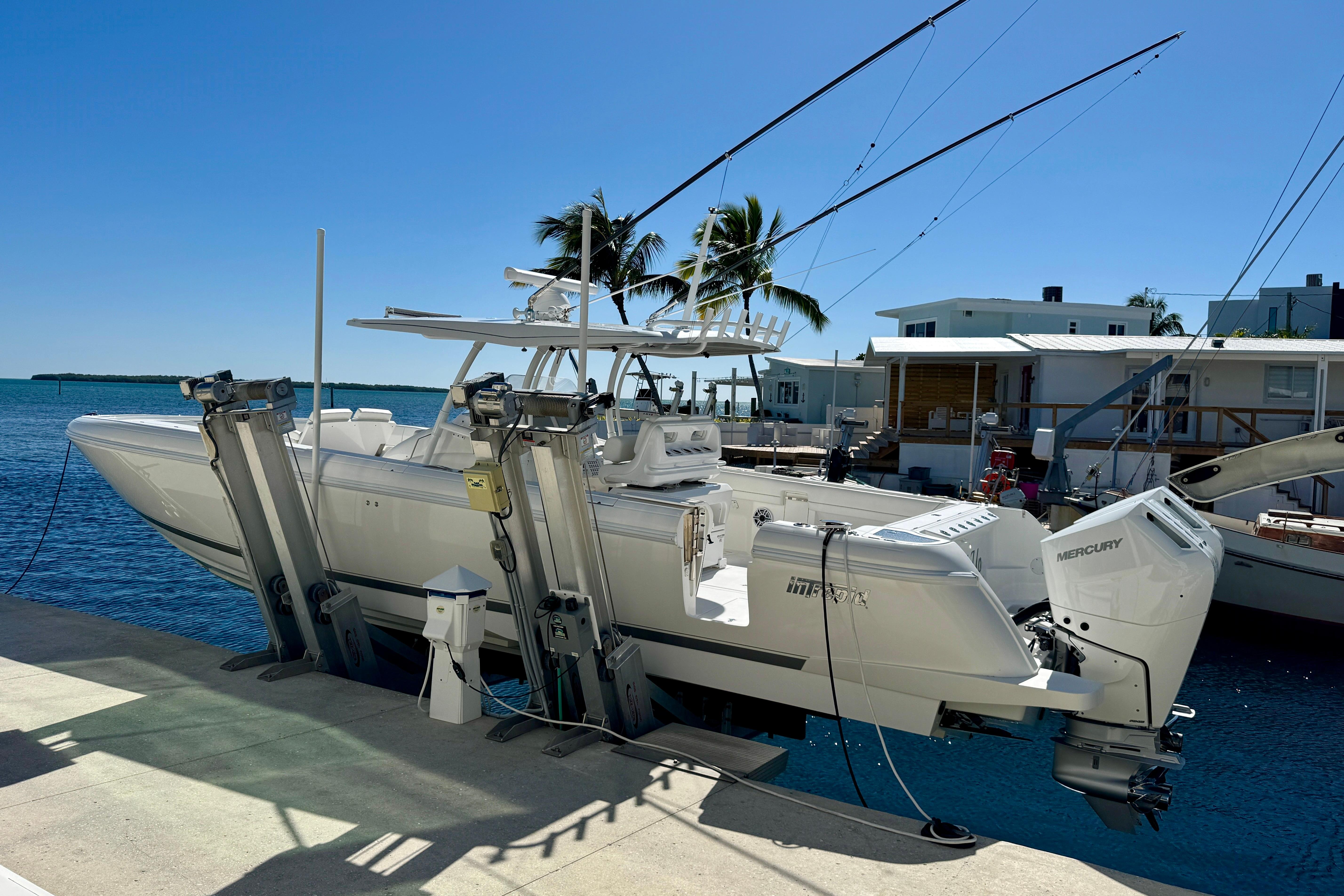 2024 Intrepid 407 Nomad FE boat docked with dual Mercury engines, under clear blue sky.
