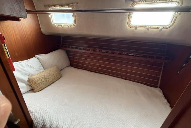 Cozy cabin interior of 1982 Lancer 45 Motorsailer with wooden accents and bedding.