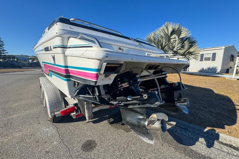 1989 Formula 292 SR-1 boat on trailer, showcasing dual propellers and vibrant stripes.