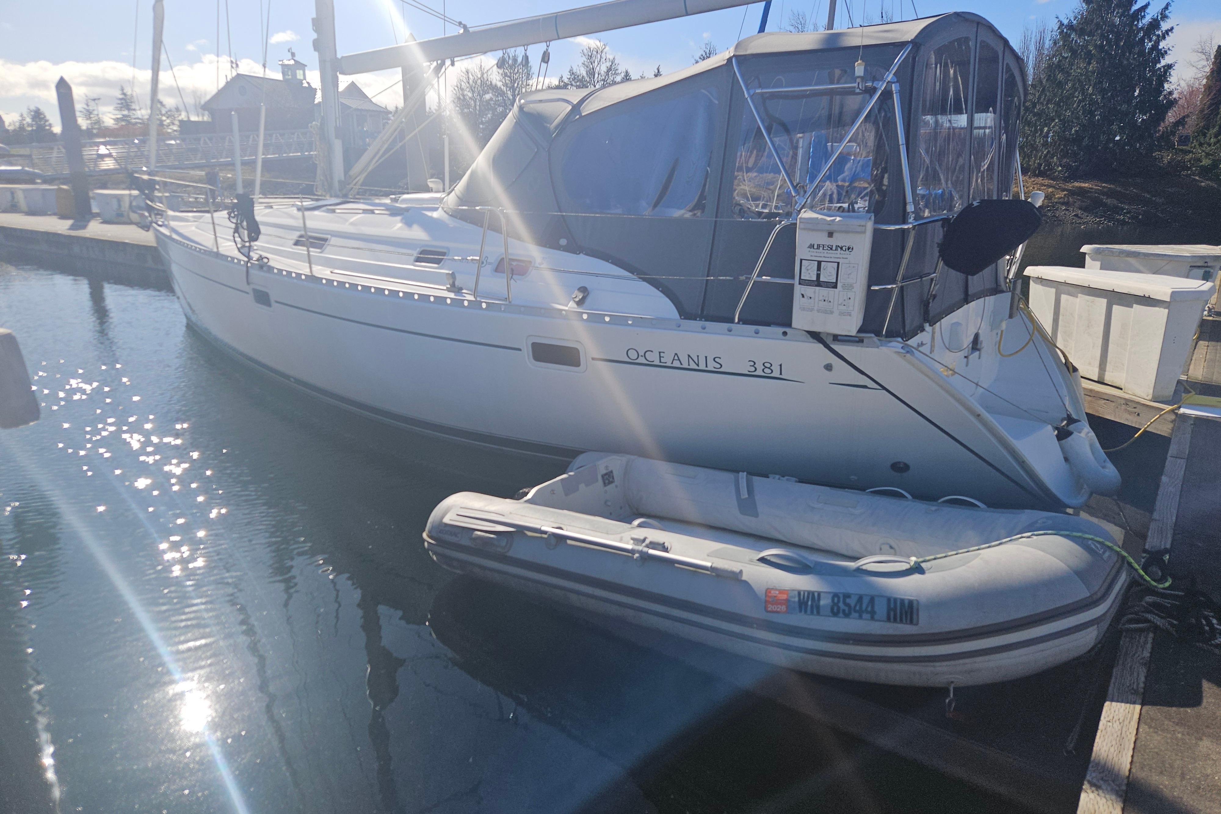 1998 Beneteau Oceanis 381 sailboat docked with inflatable dinghy in sunny marina.