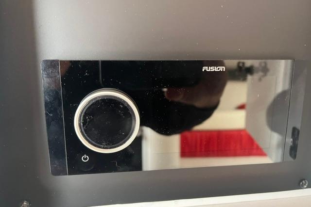 Fusion audio control panel on a 2000 Donzi 33 ZX boat dashboard.