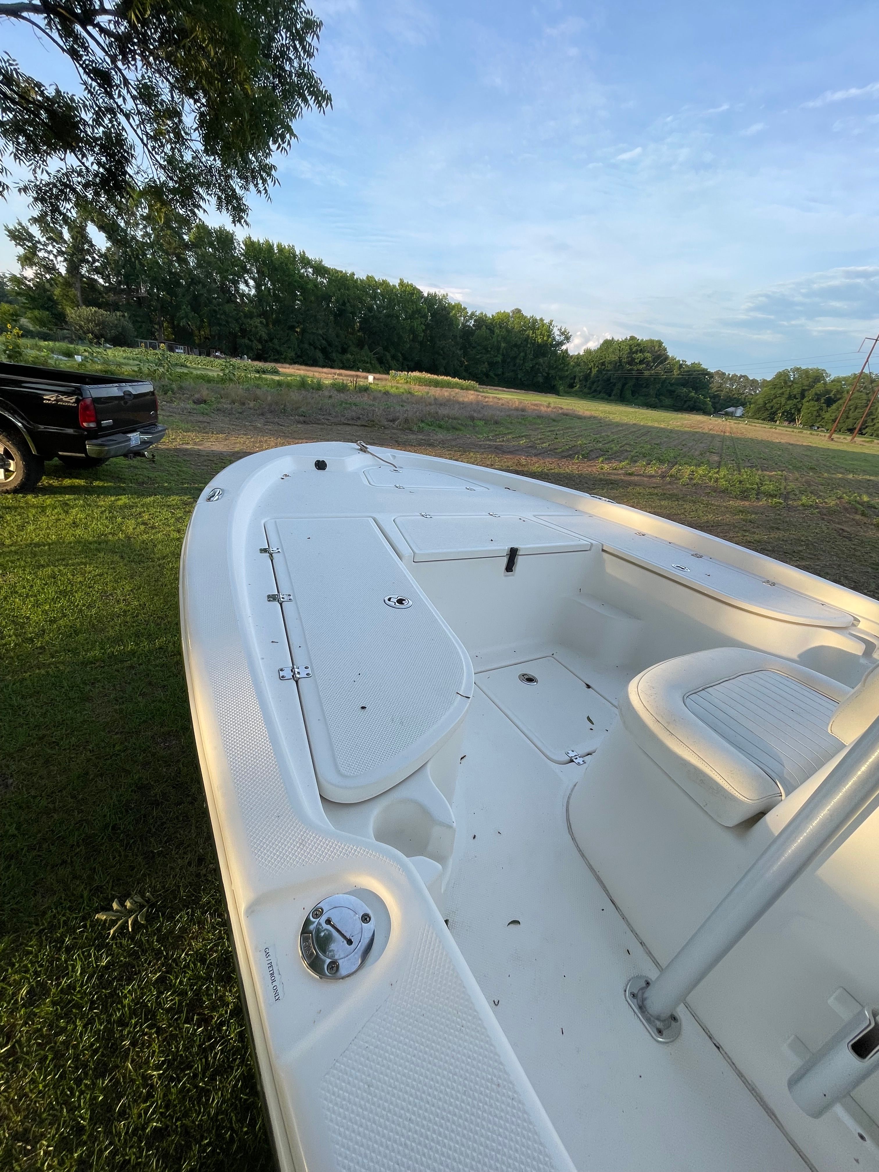 A 2012 Sea Fox 200XT boat is on grass next to a black vehicle.