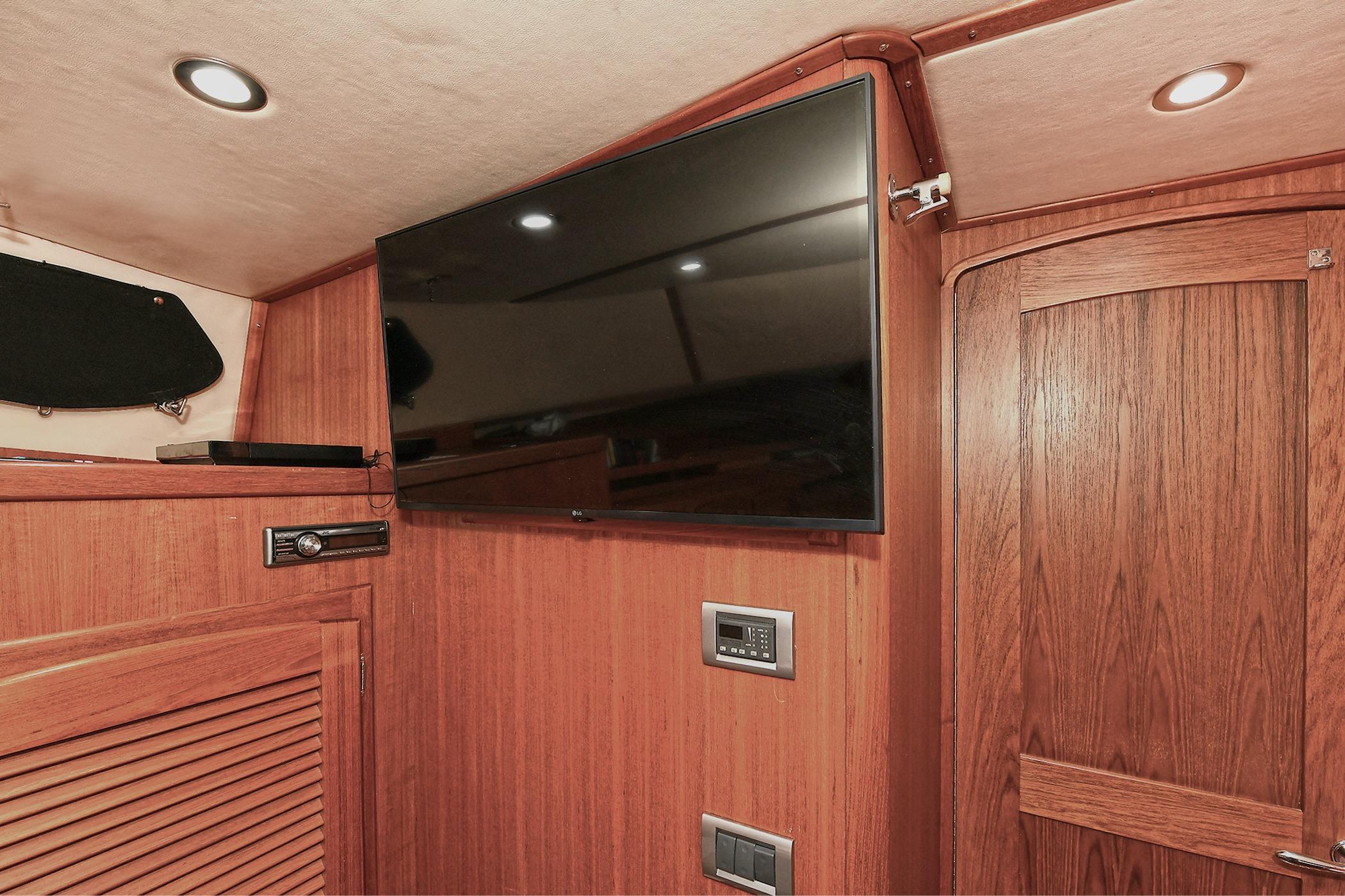 Interior of 2005 San Juan Downeast Express yacht with wood paneling and mounted TV.