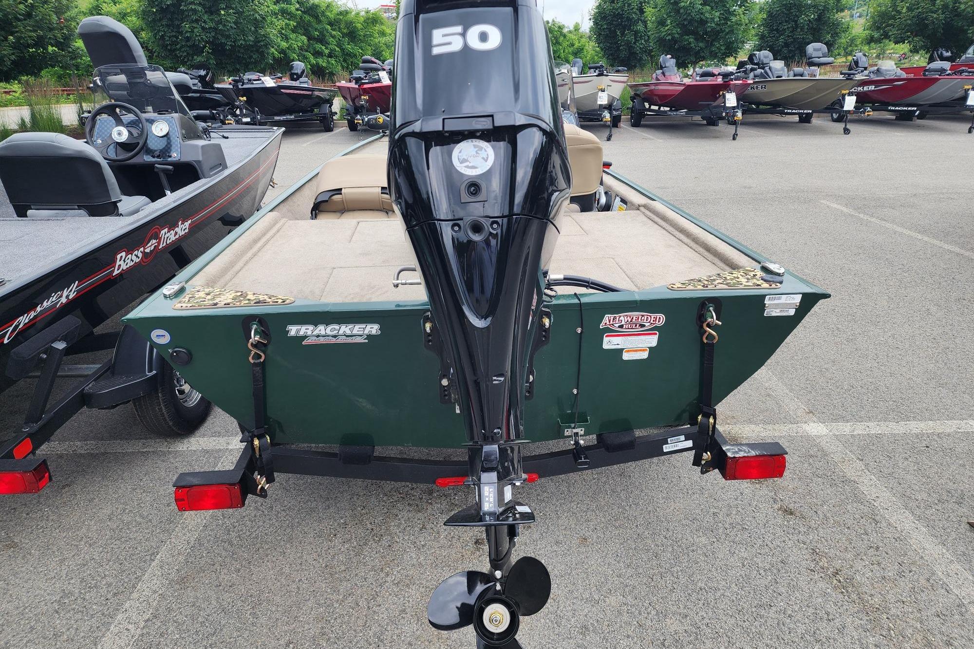 2026 Tracker Bass Tracker Classic Limited boat with outboard motor in a parking lot.