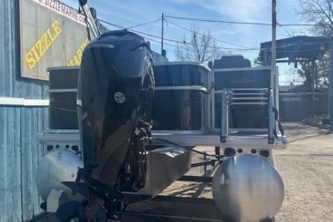 2026 Sun Tracker Party Barge 18 DLX pontoon boat with outboard motor, docked outdoors.