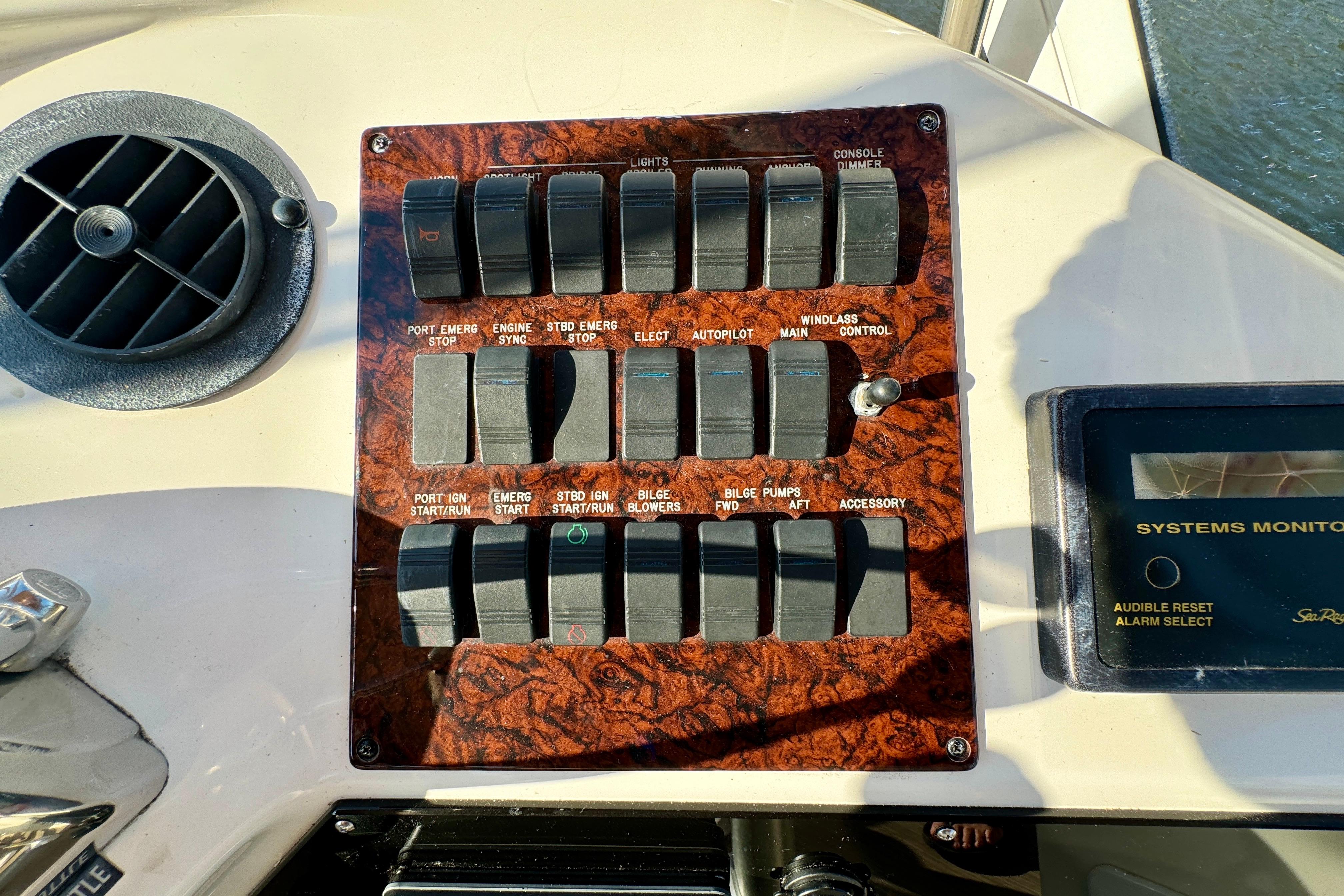 Control panel of a 2003 Sea Ray 400 Sedan Bridge yacht with various switches and systems monitor.