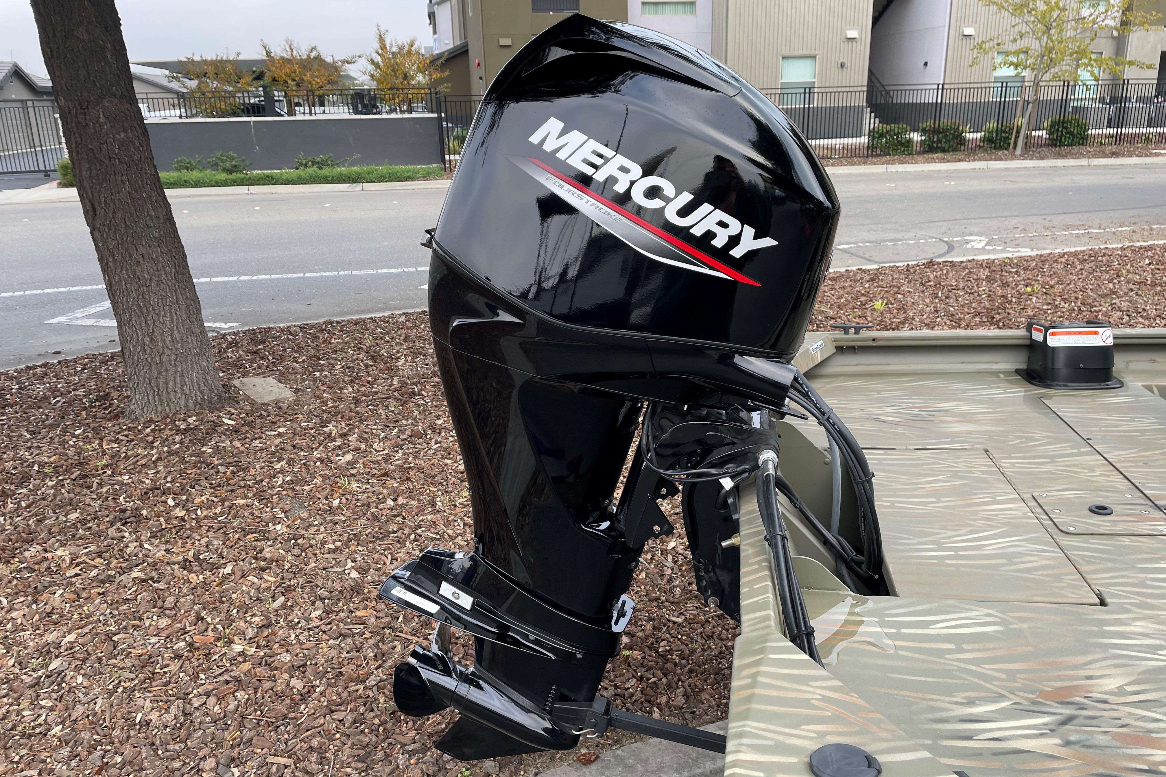 2025 Tracker Grizzly 1754 SC boat with Mercury outboard motor, parked outdoors.