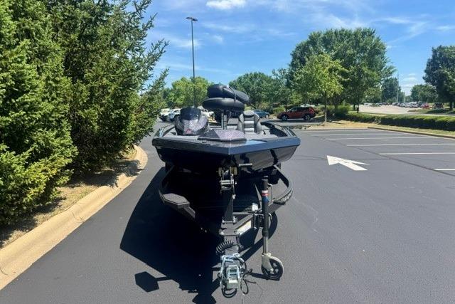 2026 Ranger RT198P boat parked on asphalt, surrounded by trees and clear blue sky.