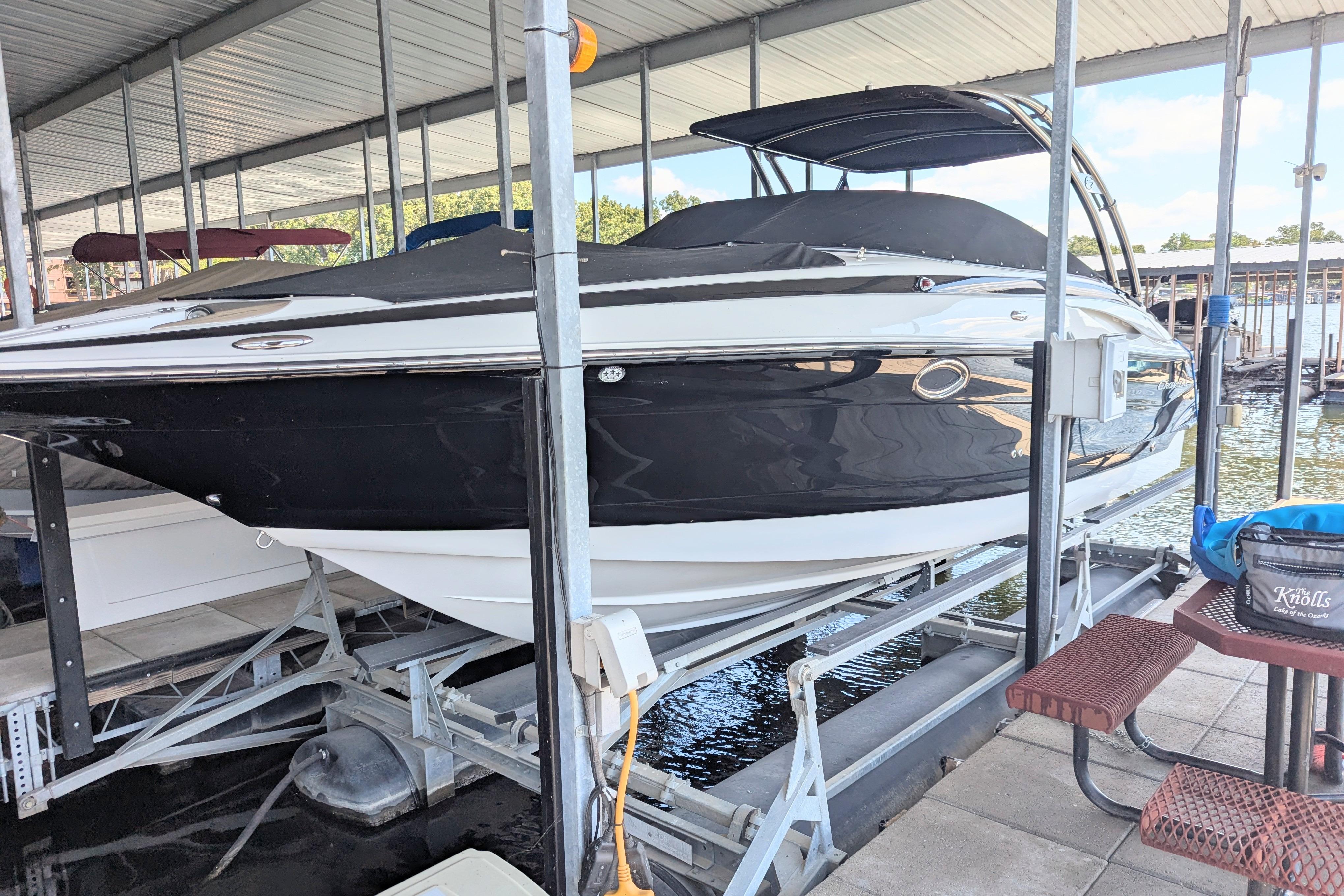 2008 Crownline 300 LS boat docked in a covered marina, side view.