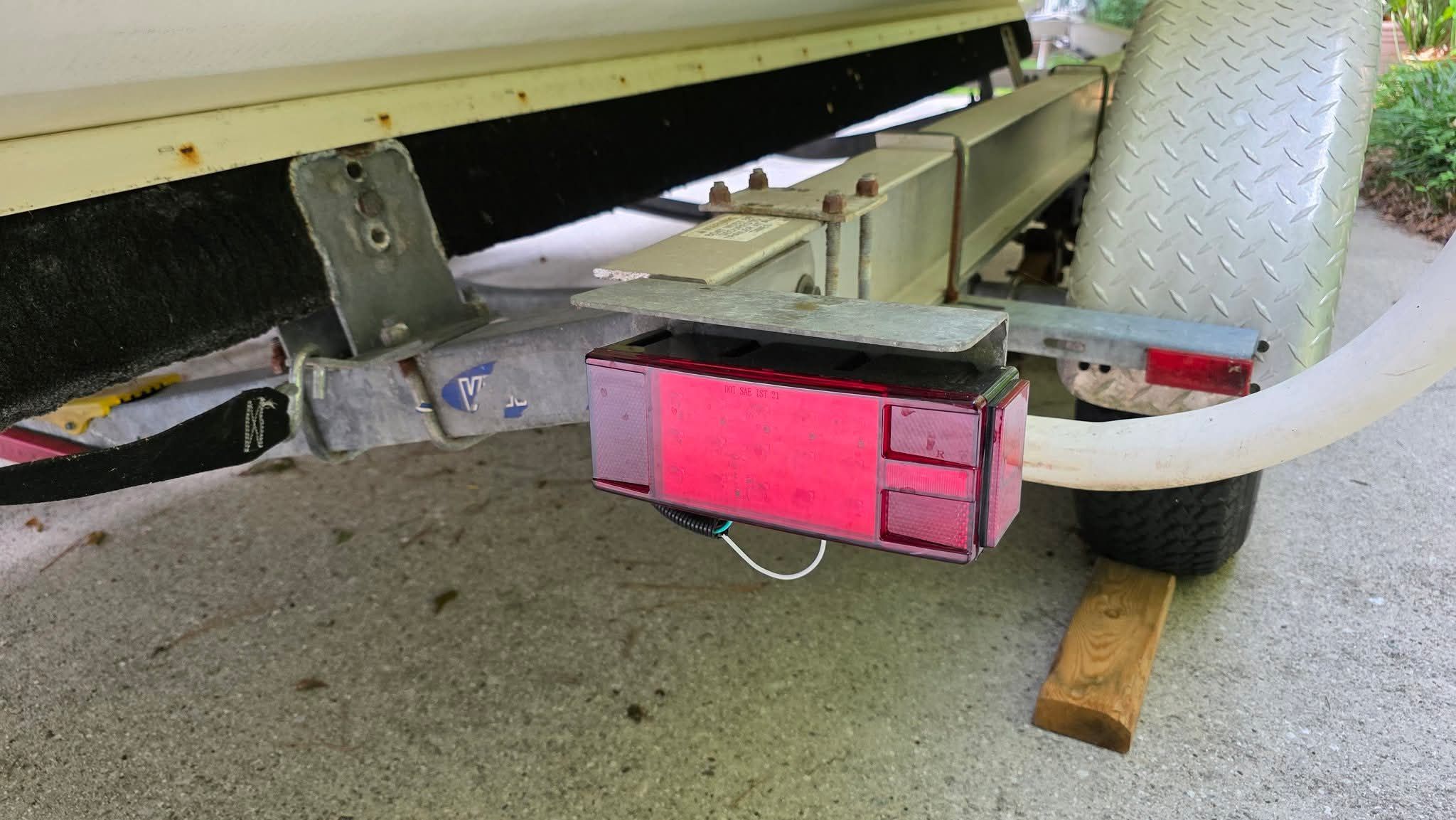 Close-up of a boat trailer with red taillight and metal frame.