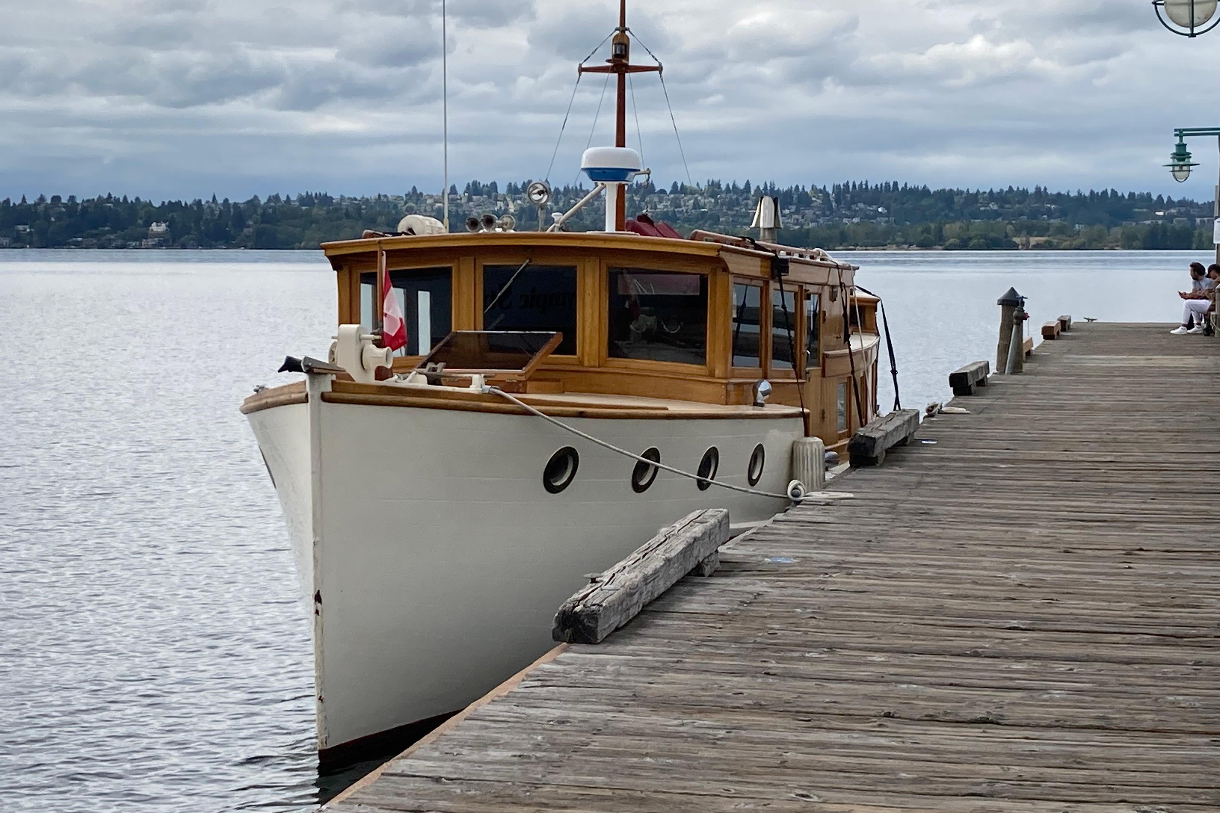 Vintage 1942 Grenfell 42 Custom boat docked by a wooden pier on a cloudy day.