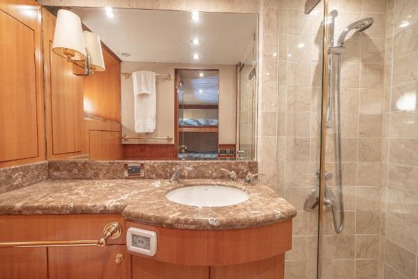 Luxurious bathroom in a 2001 Grand Harbour 76 yacht with marble countertop and modern shower.