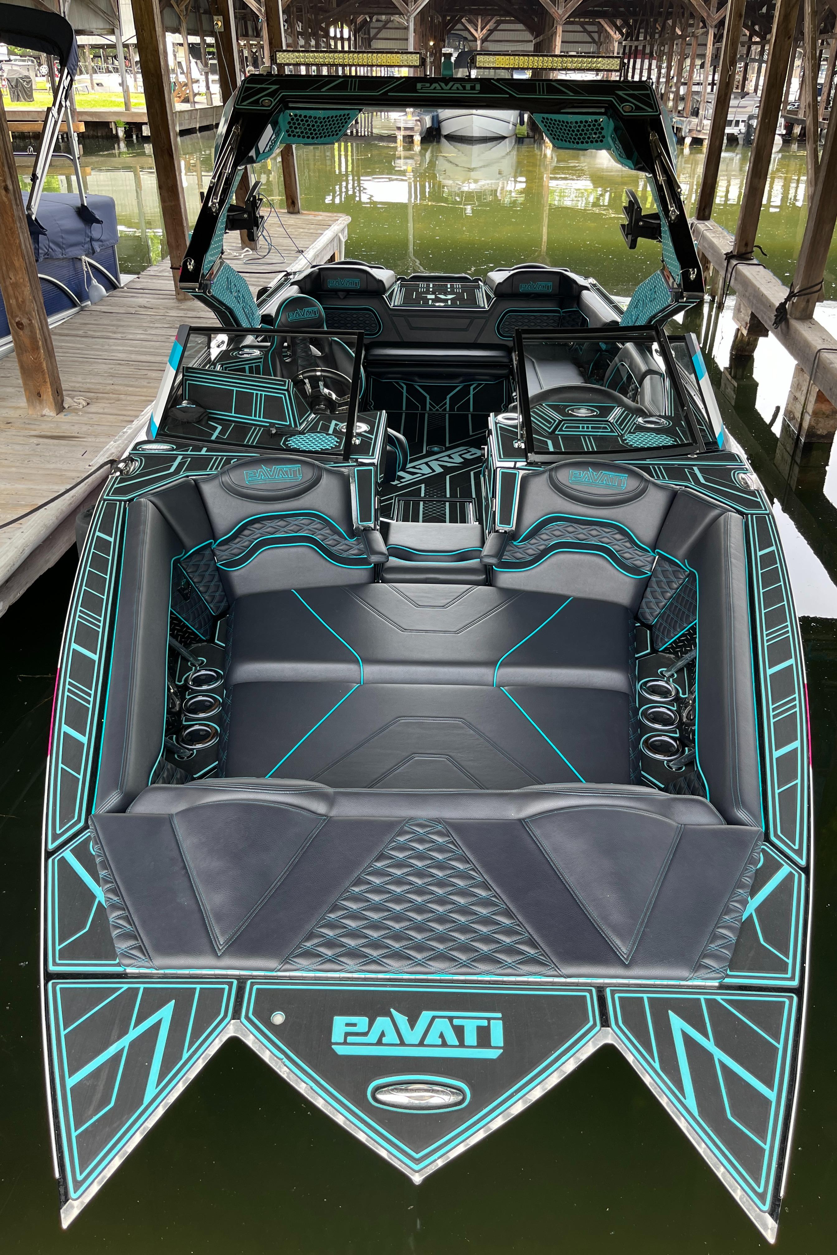 2021 Pavati AL26 boat with sleek black and teal interior design, docked in a marina.