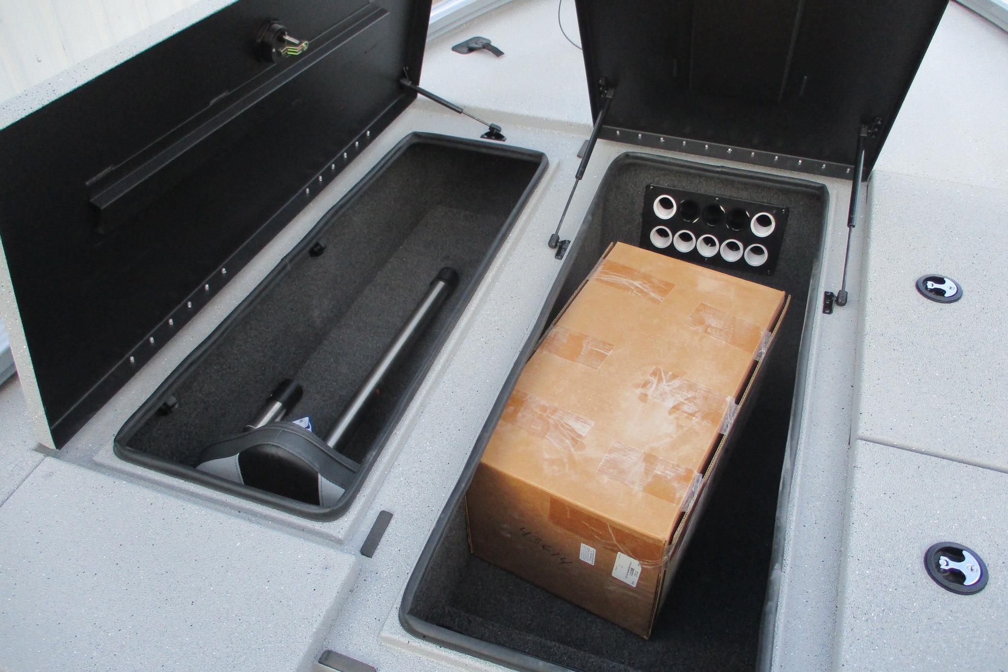 Open storage compartments on a 2026 Vexus AVX2080 boat, featuring a cardboard box.