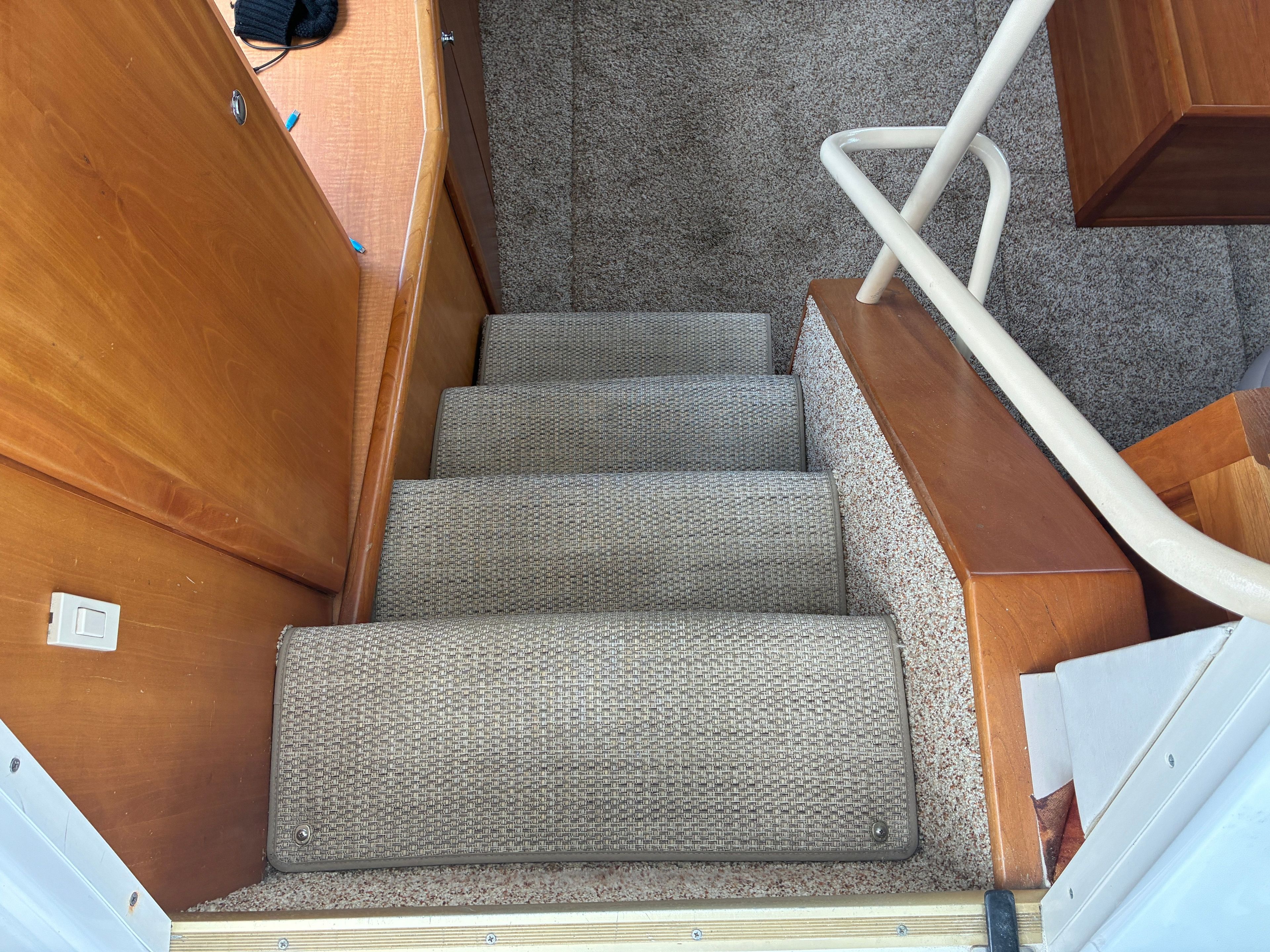 Carpeted steps lead into the interior of the 2001 Silverton 392 Motor Yacht.