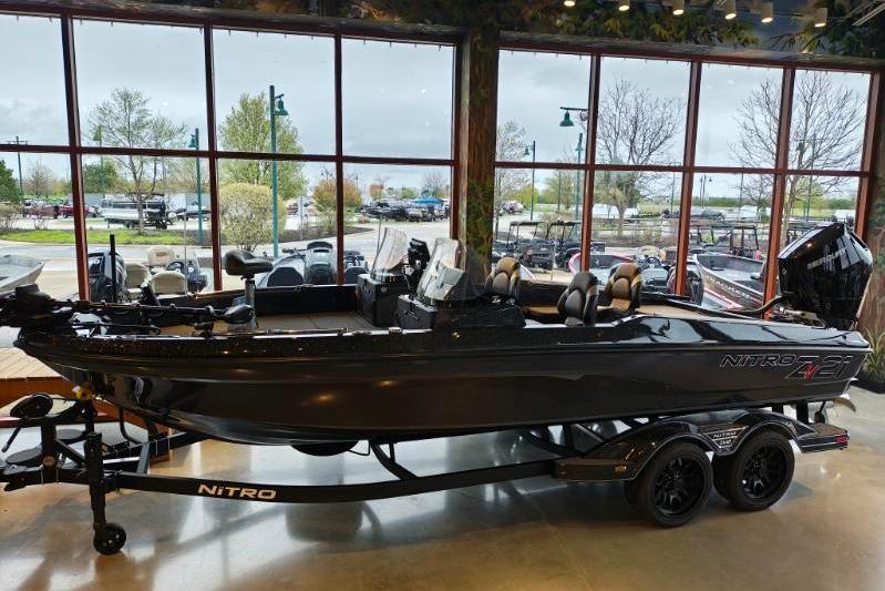 2026 Nitro ZV21 boat displayed indoors with trailer, large windows in background.