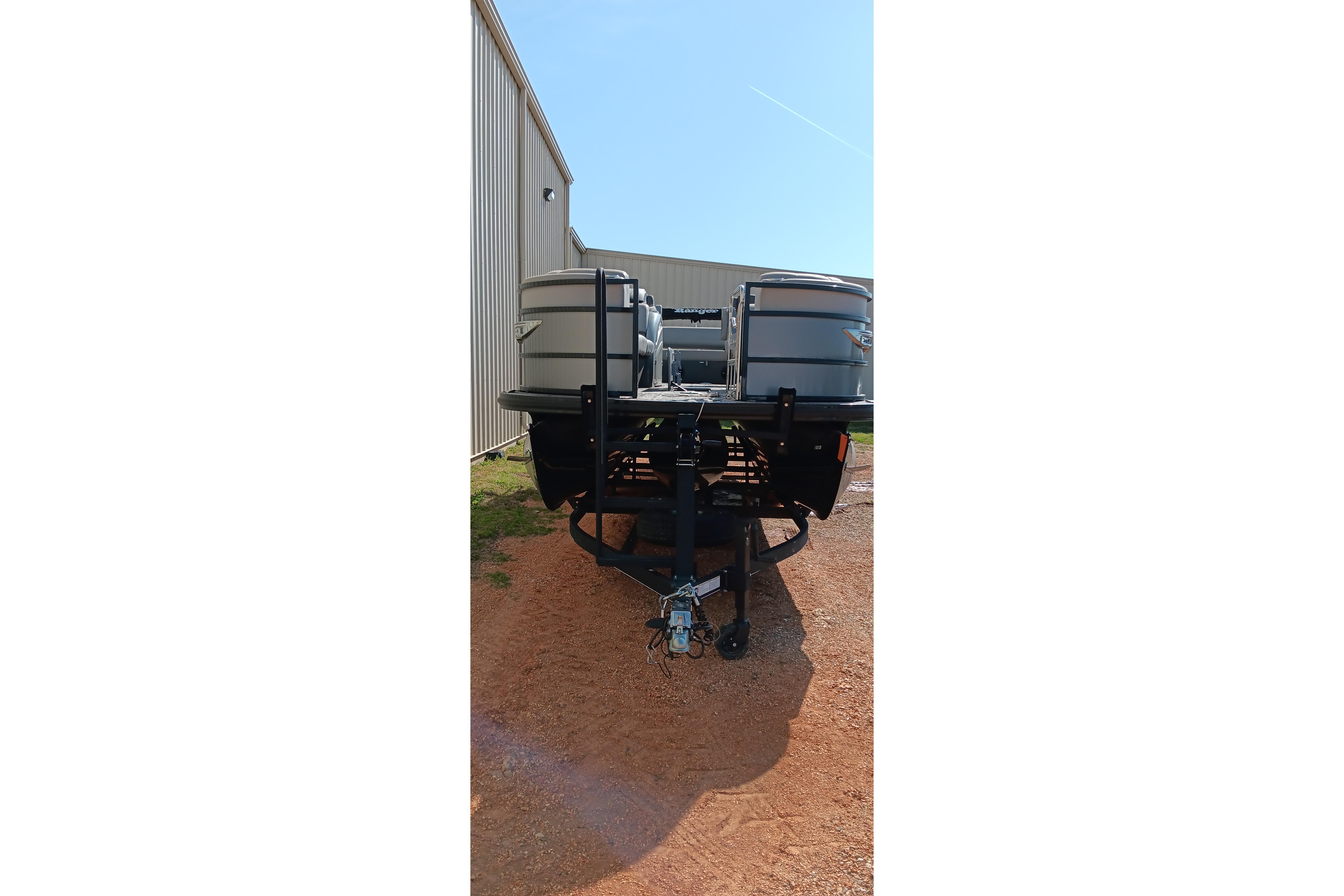2023 Ranger 2500LS pontoon boat on trailer, parked beside a metal building.
