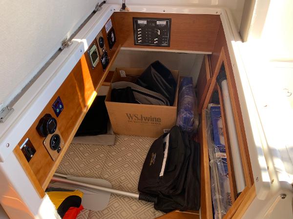Storage compartment in a 2021 Cutwater C-32 CB boat with various equipment and controls.