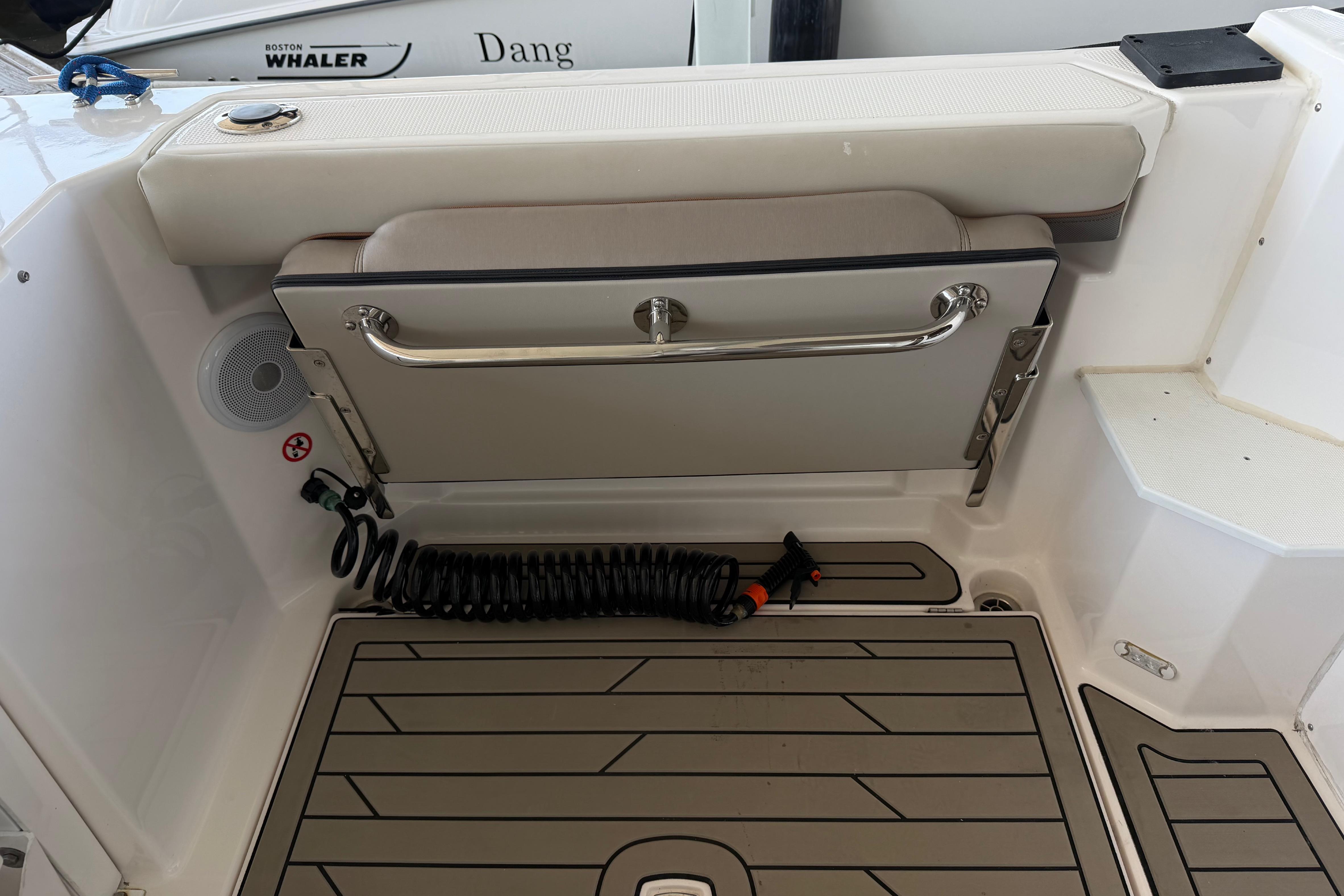 2023 Cutwater C-288 Coupe boat deck with foldable seat and coiled hose.