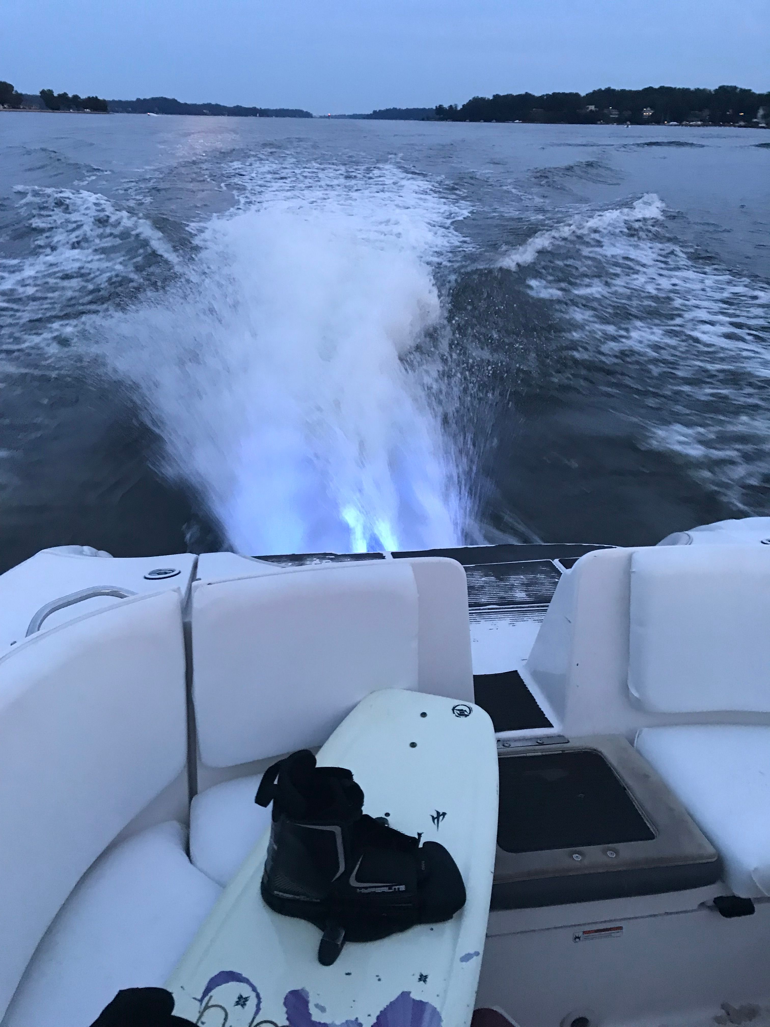 Yamaha SX230 HO 2005 boat with wakeboard on lake.
