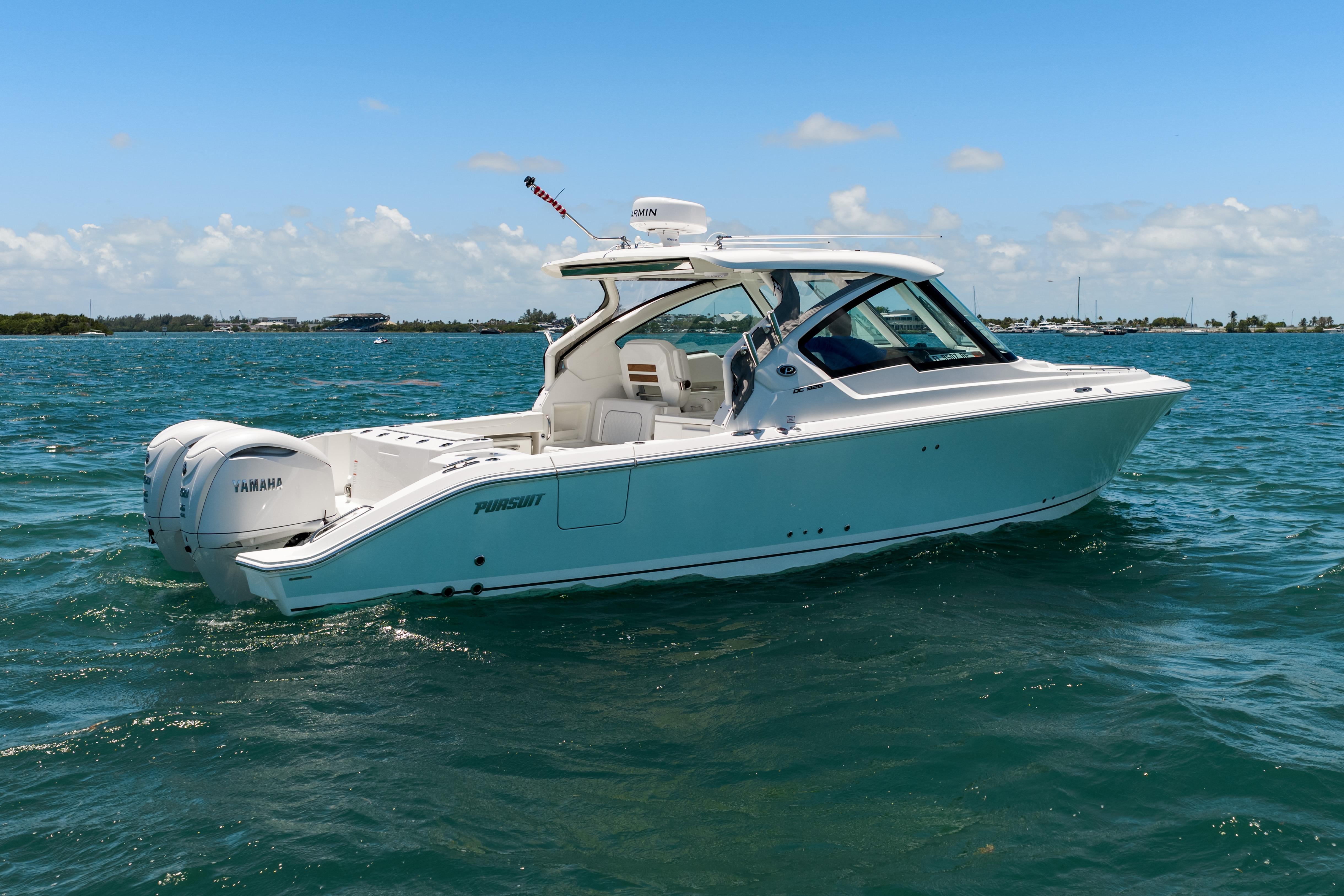 2026 Pursuit DC 326 Dual Console boat on open water under clear blue sky.