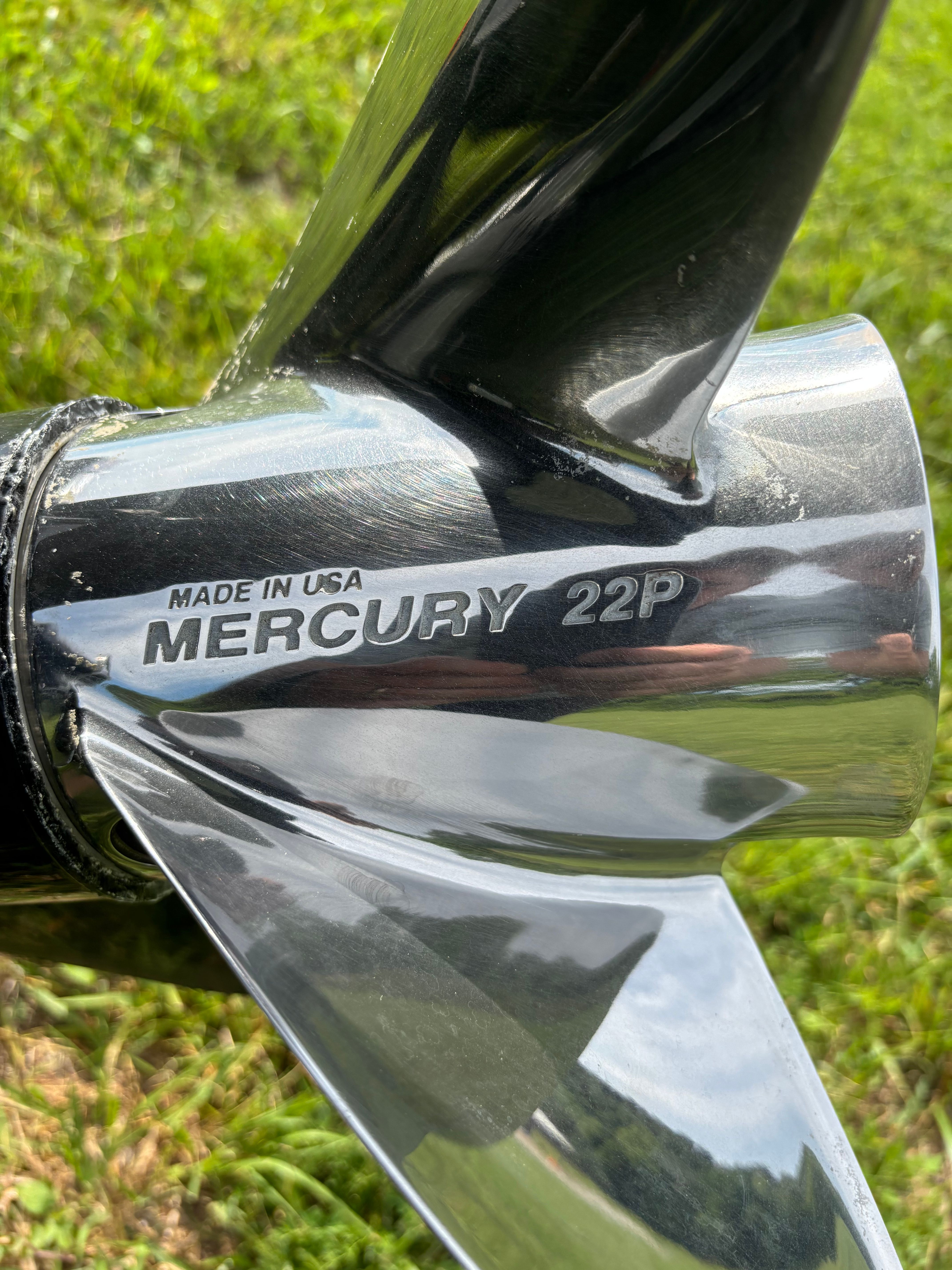 Close-up of a Mercury propeller on grass.
