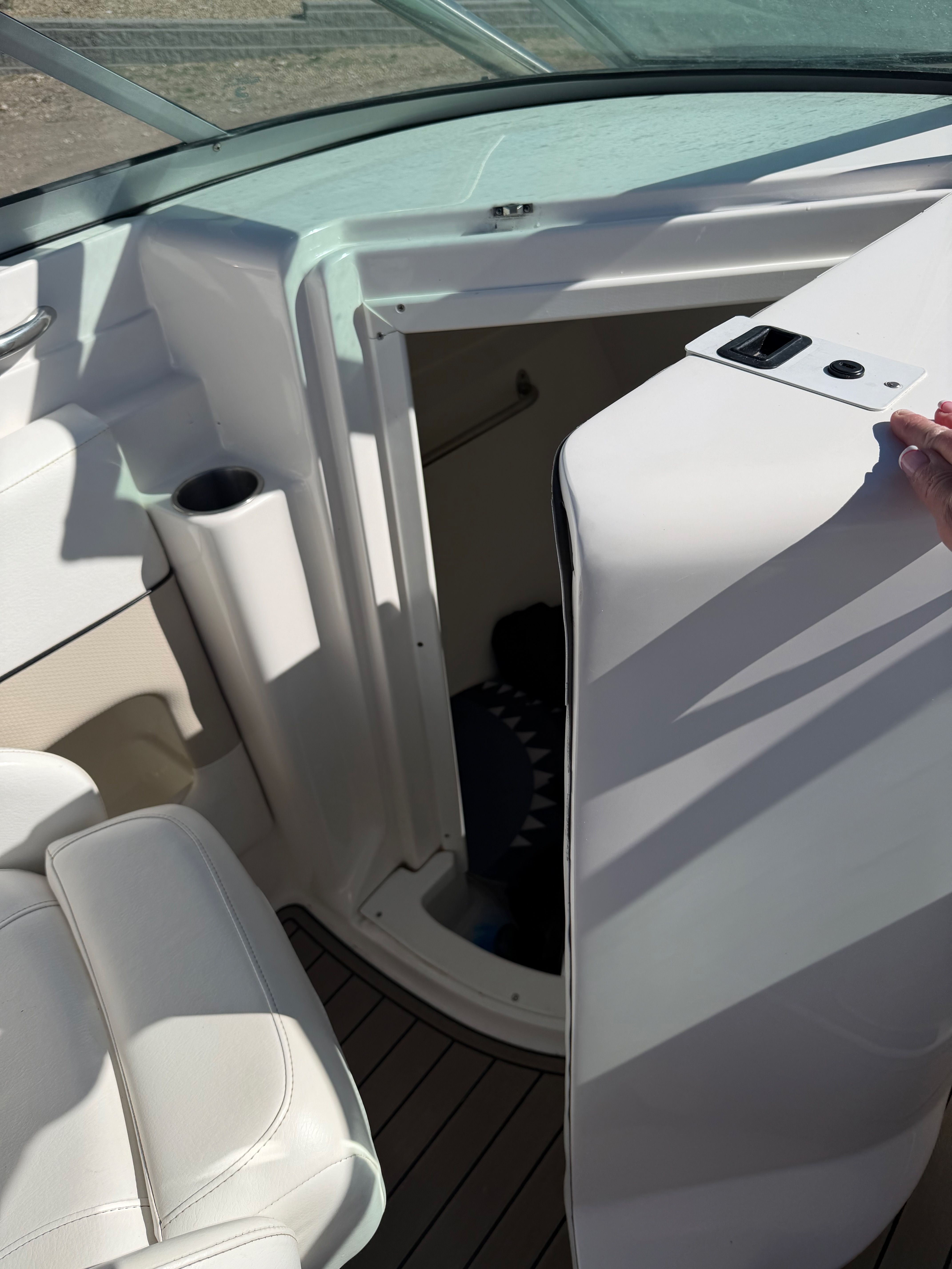 Interior view of a 2007 Rinker 246 Captiva Bowrider with white seating and cabin access.