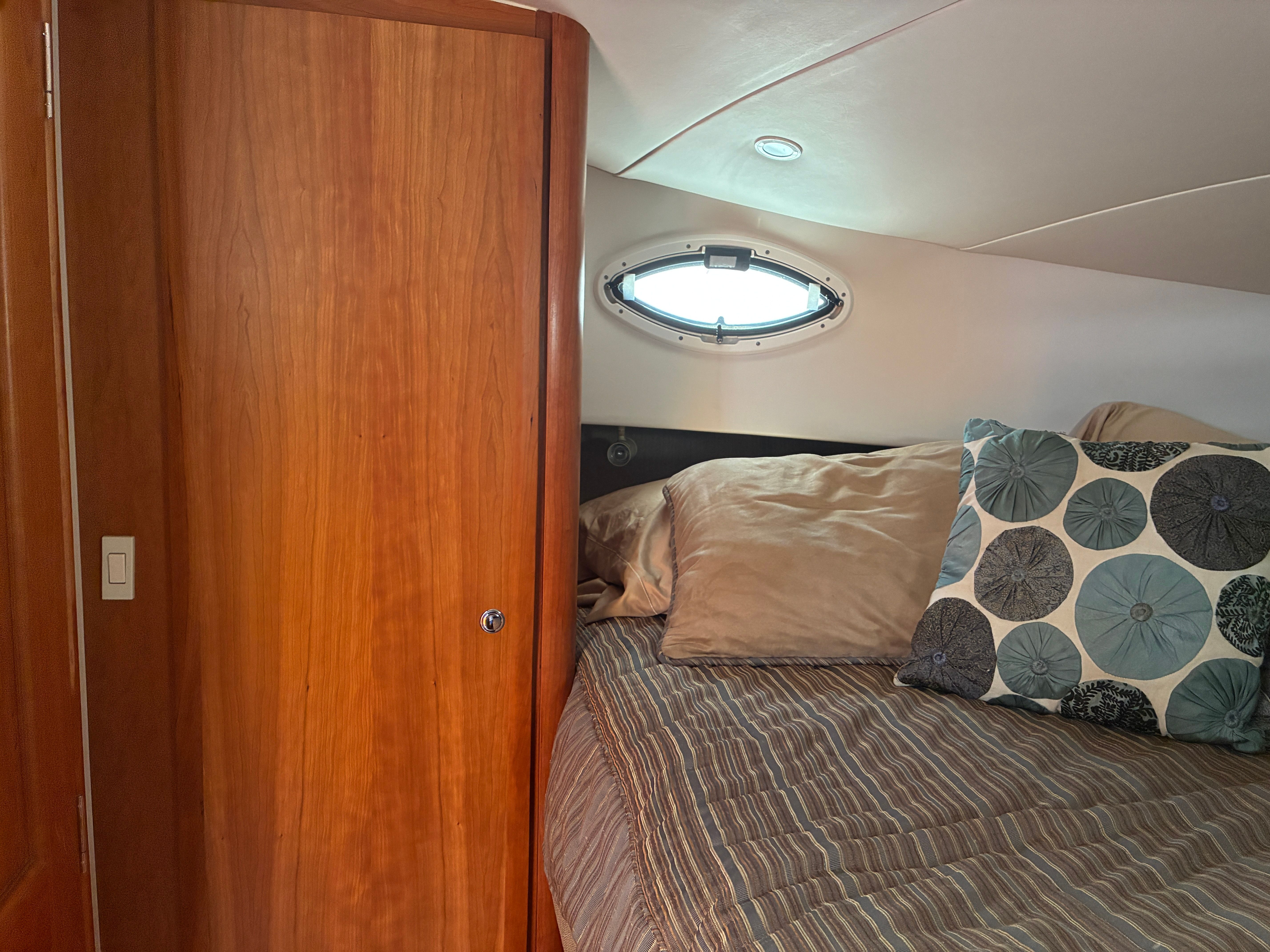 Interior of the 2001 Silverton 392 Motor Yacht with a cozy bed and wooden furnishings.