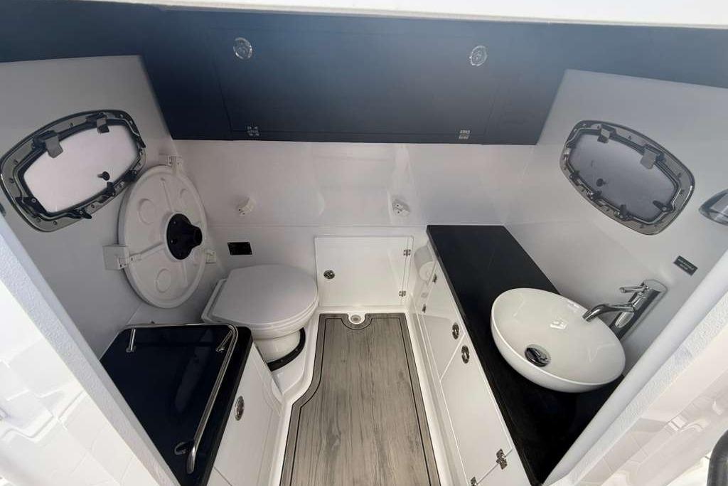 Modern bathroom interior of 2026 Monterey Elite 30 OB boat, featuring sleek fixtures and wood flooring.