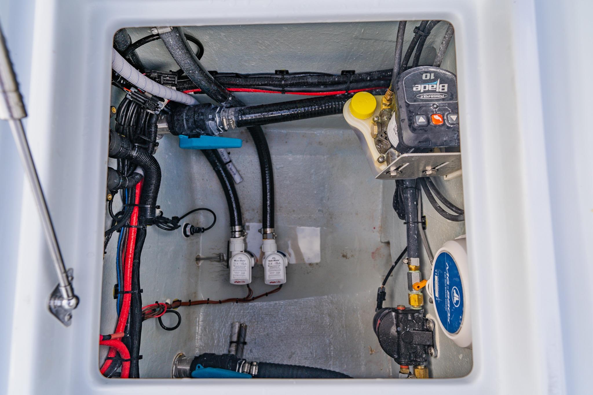 Bilge compartment of 2026 Broadwater 25 Bay Cat boat with wiring and pump system.