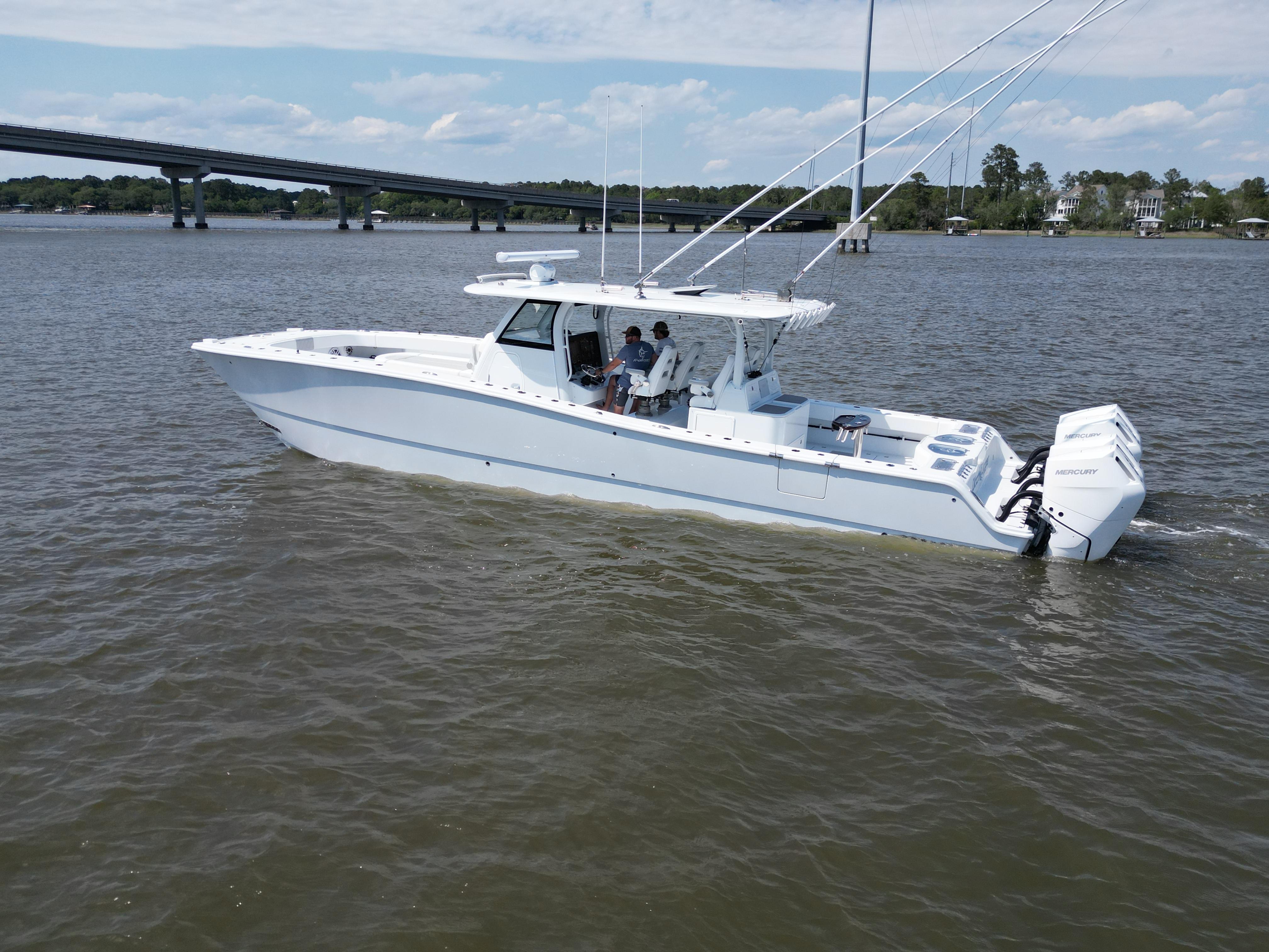 2024 Freeman 43 boat cruising on a river with a bridge in the background.