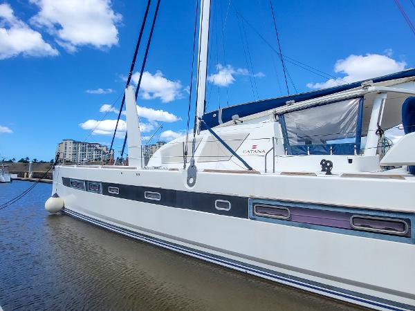 2009 Catana 65 yacht docked in marina under blue sky.