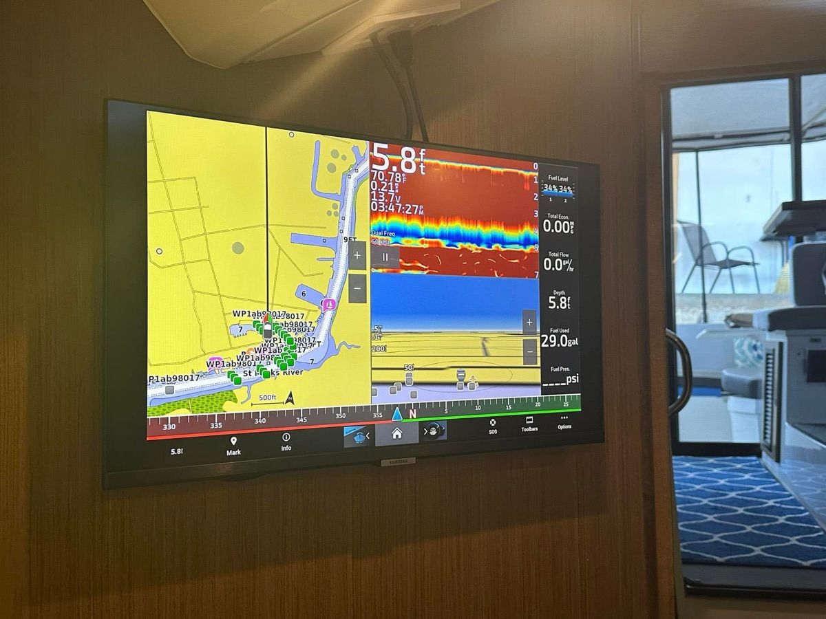 A navigation screen on a boat displays maps and depth information.