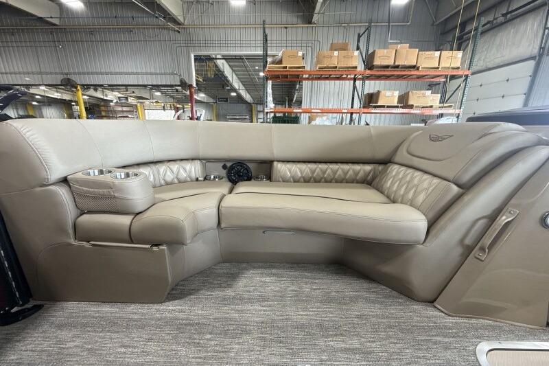 Luxurious seating on the 2026 Bennington 24 LXS Quadbench pontoon boat in a warehouse setting.