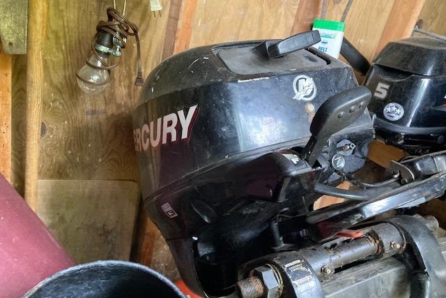 Mercury outboard motor in a wooden shed, near Mainship 430 Trawler equipment.